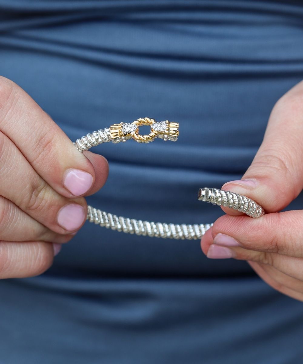 Hands holding a VAHAN bracelet, flexed open