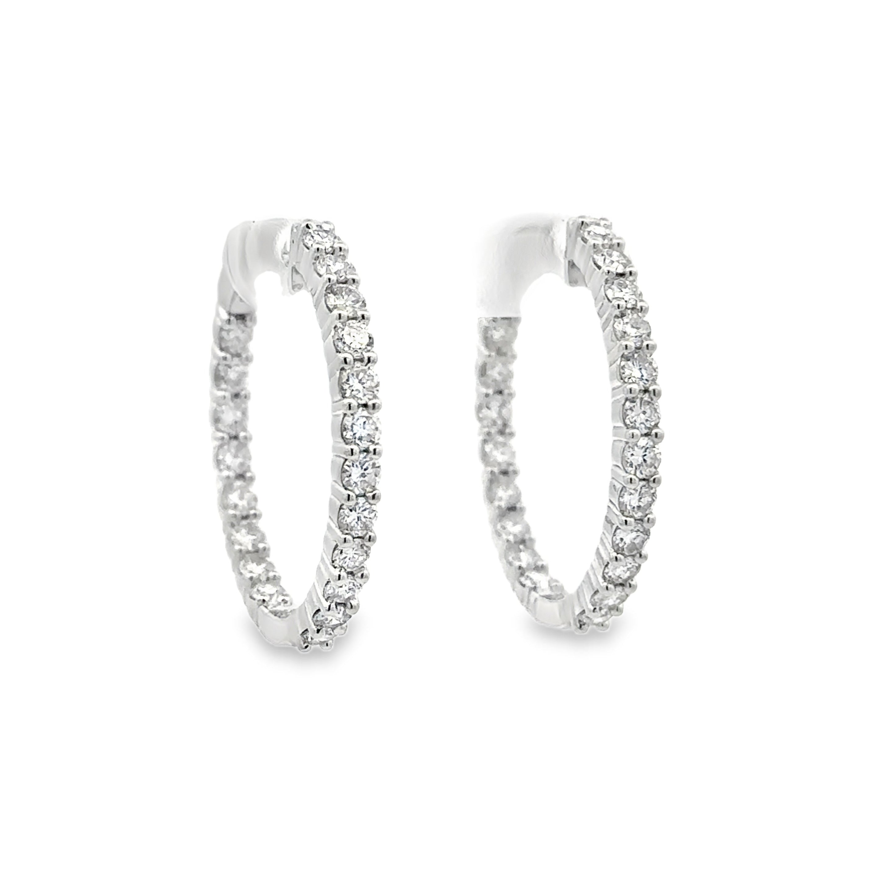 Pair of silver hoop earrings with clear gemstones on a white background