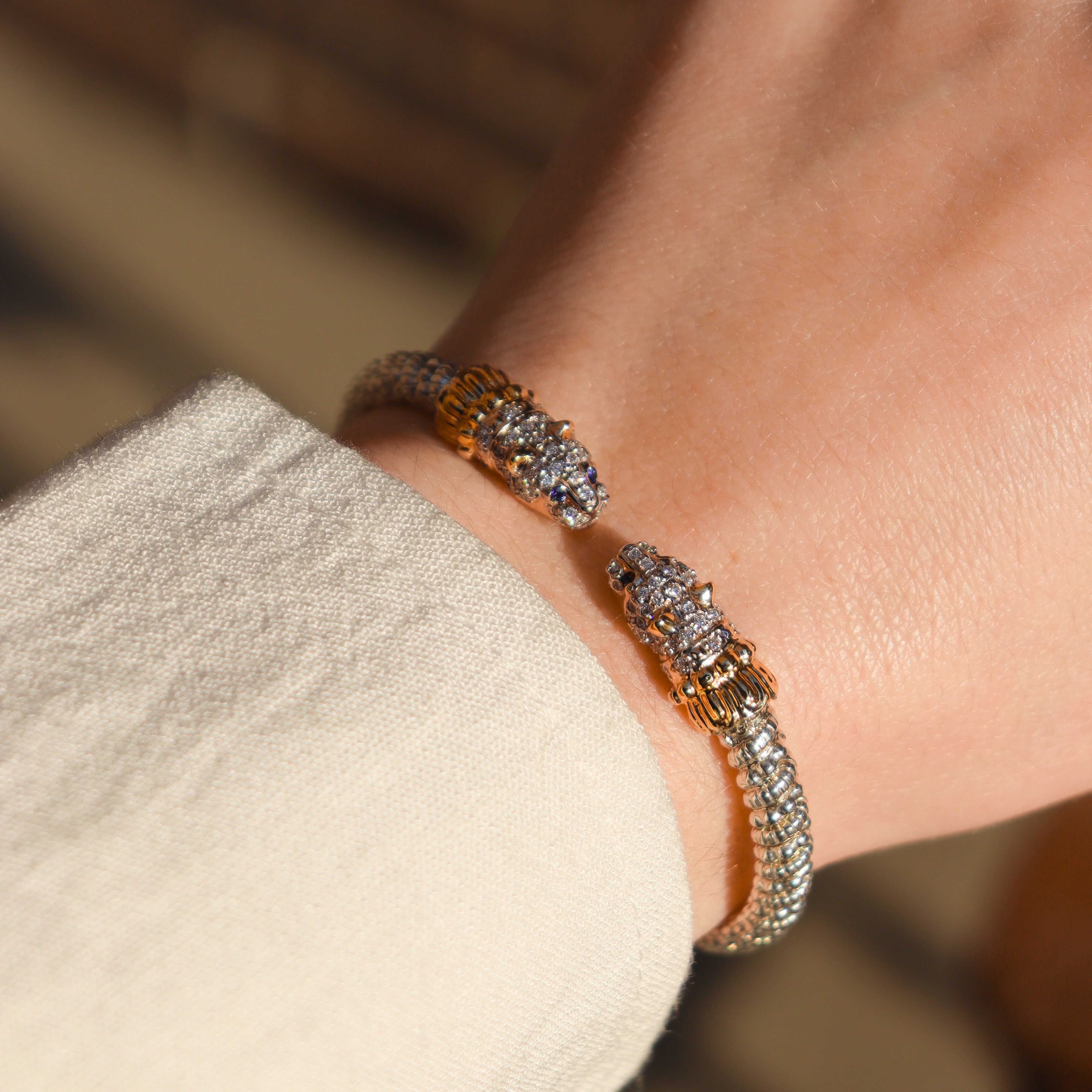 Close-up of a person's wrist wearing a designer Jaguar bracelet with a blurred background