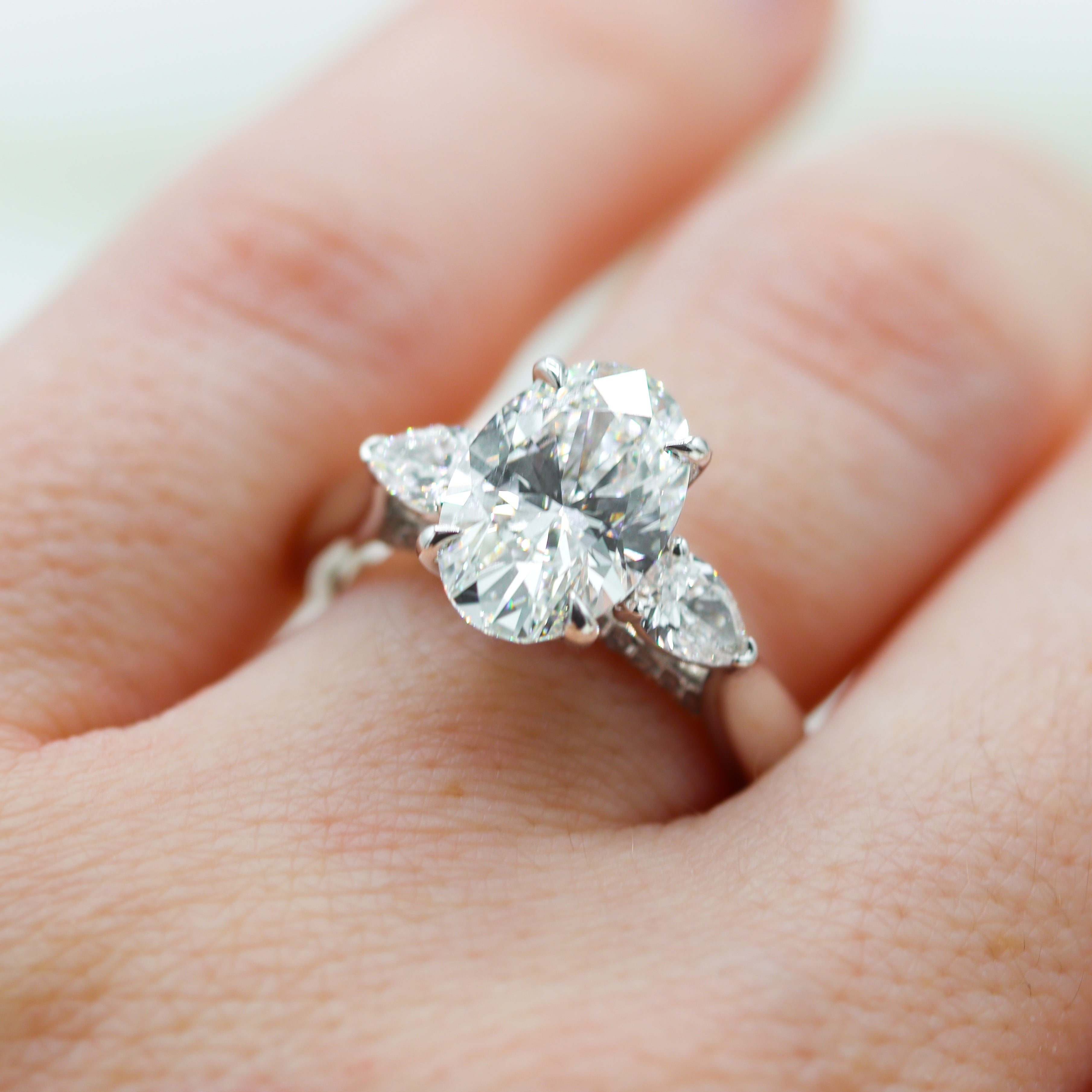 14K White Gold 3-2/3CTW. Certified Oval-Cut Lab-Grown Diamond 3-Stone Accented Engagement Ring on a hand