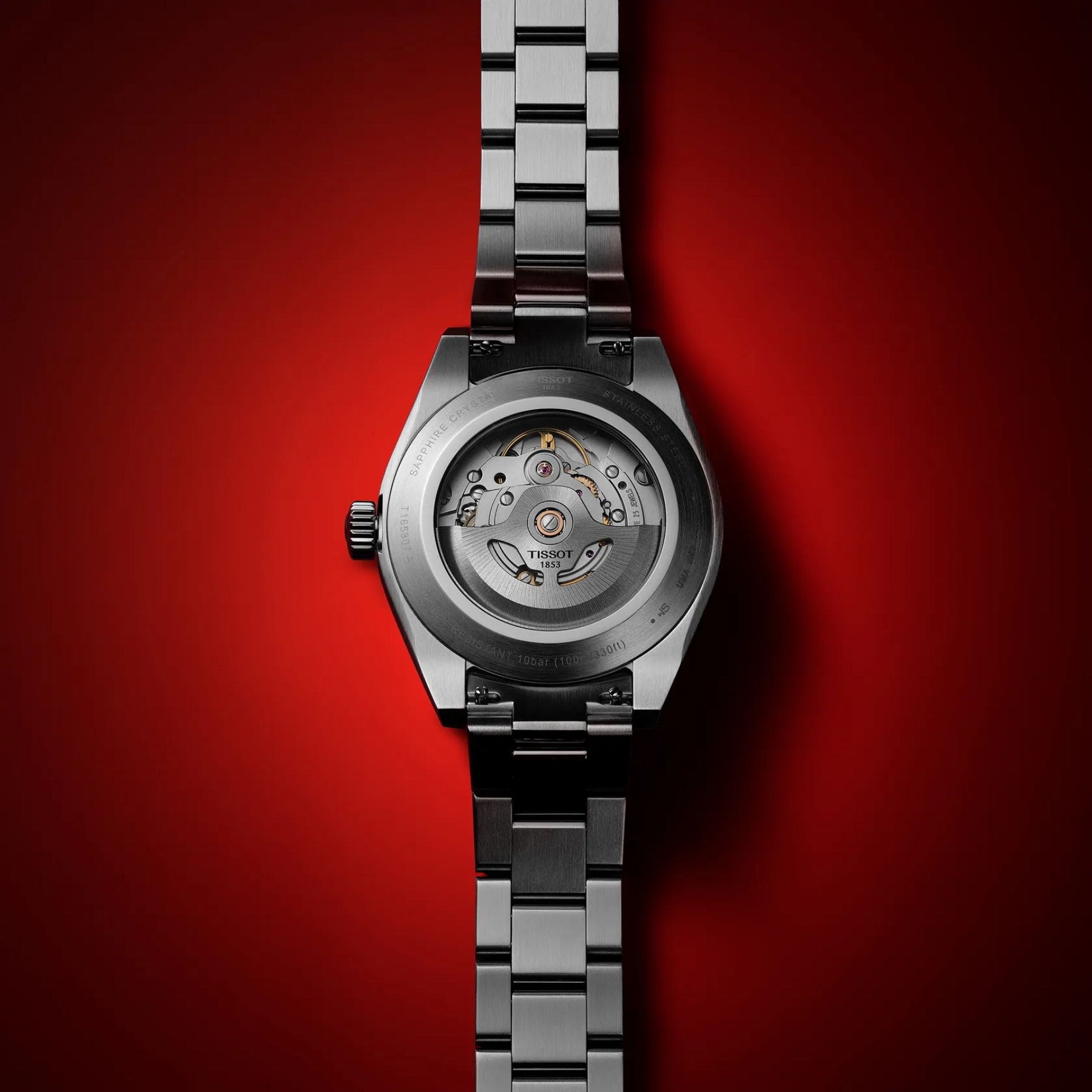 Silver watch with visible brand logo on a red background