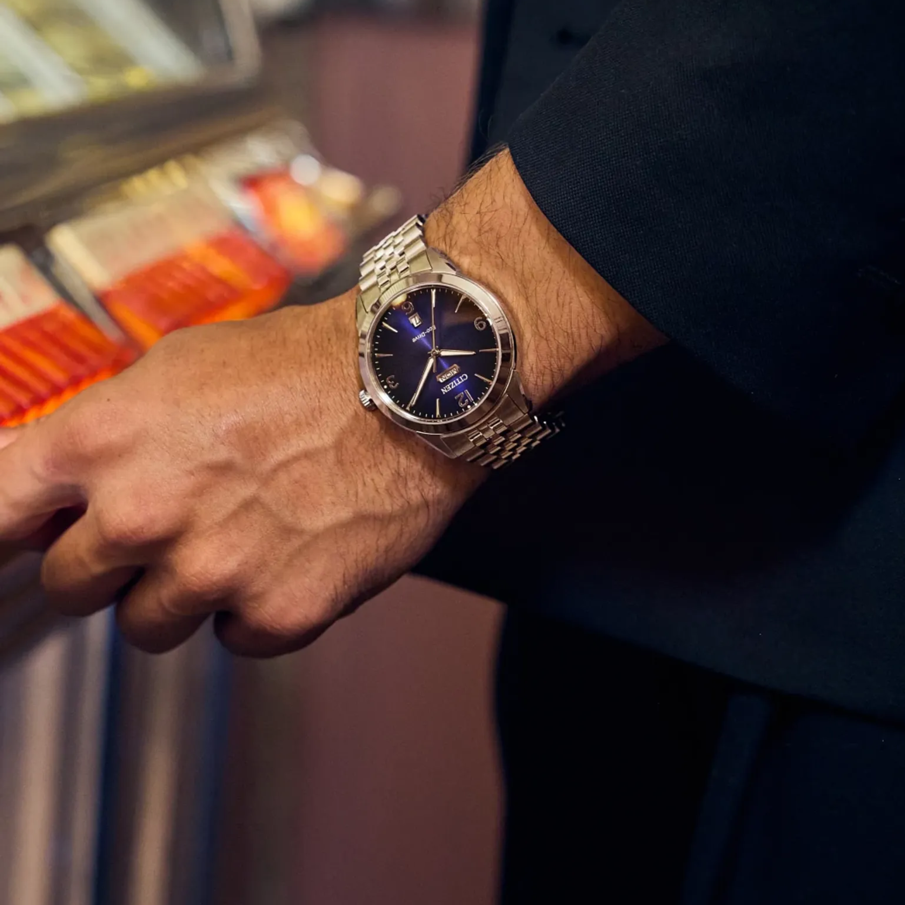 Close-up of a person's wrist wearing a gold watch with a dark face.