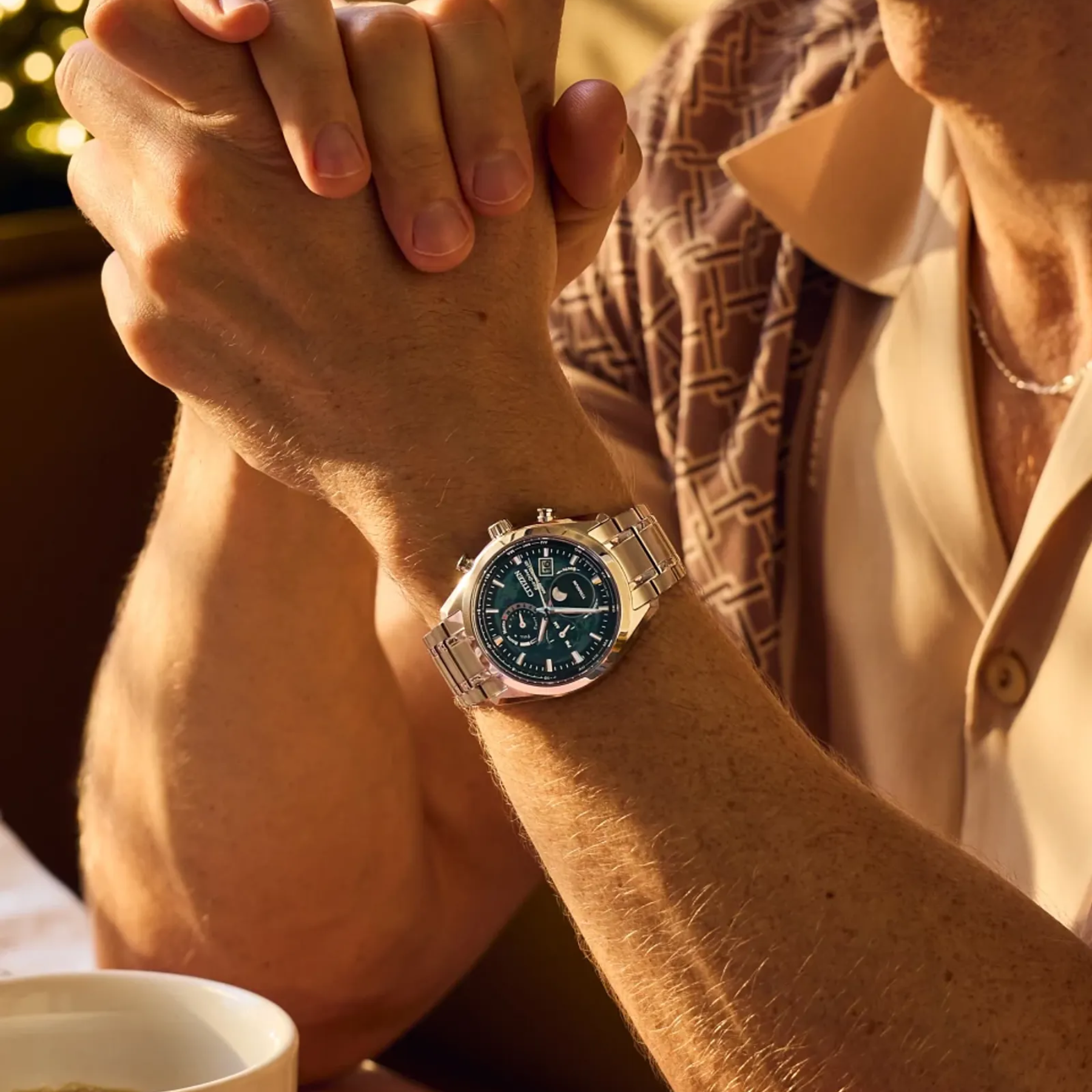 Close-up of a person's wrist wearing a watch with a blurred background