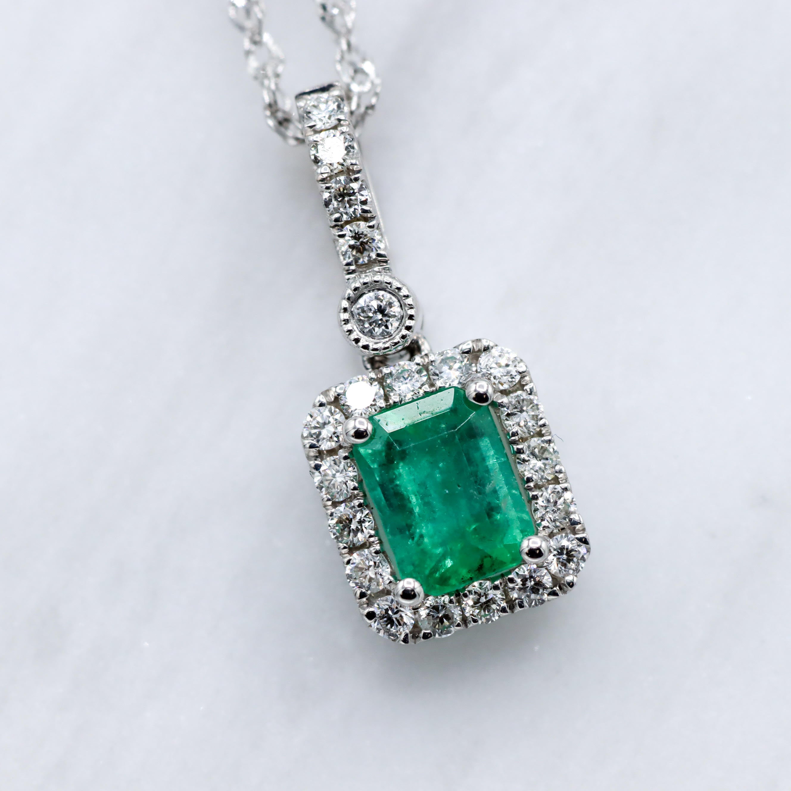 14K White Gold Emerald-Cut Emerald and 1/6CT. Diamond Halo Pendant Necklace