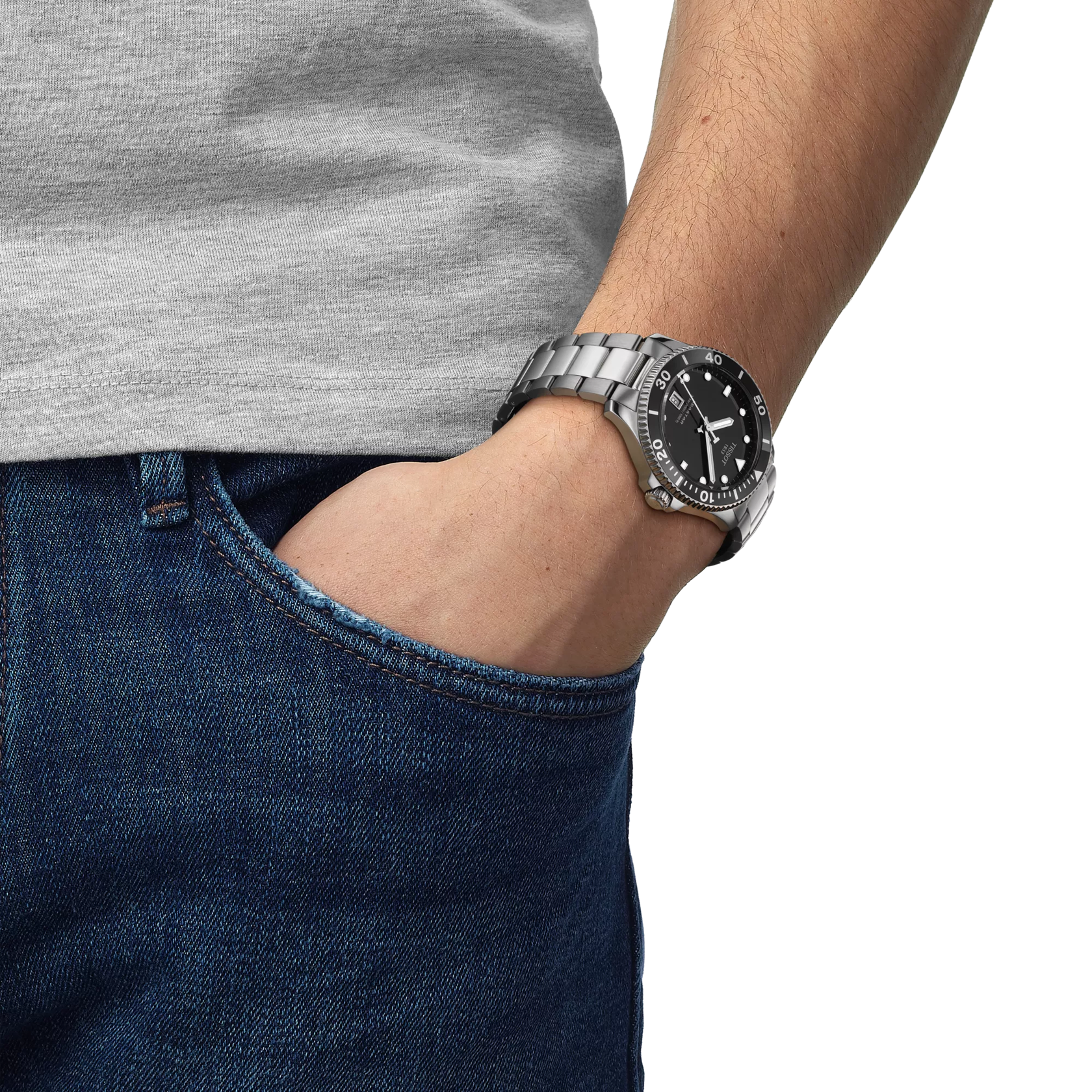 Person wearing a silver watch with a black face on a white background