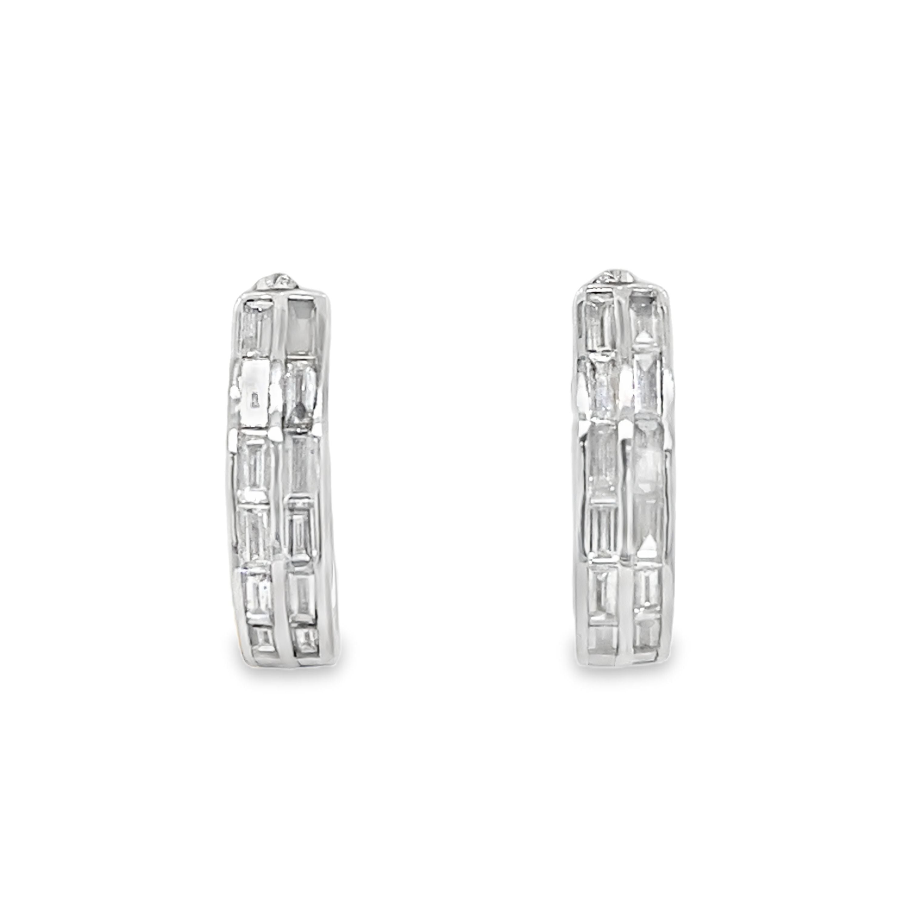 Pair of silver hoop earrings with baguette cut stones on a white background