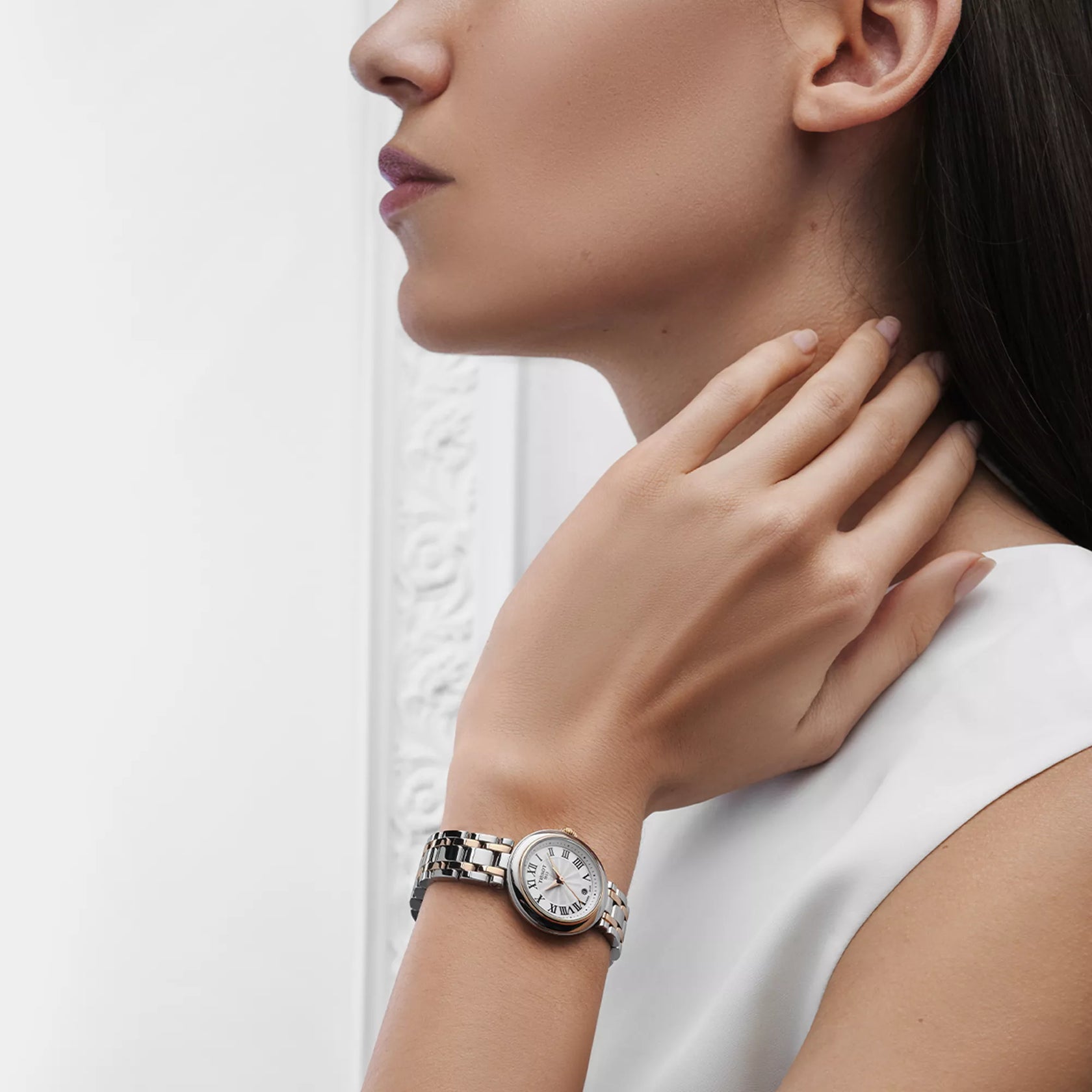 Woman wearing a silver watch with a white background