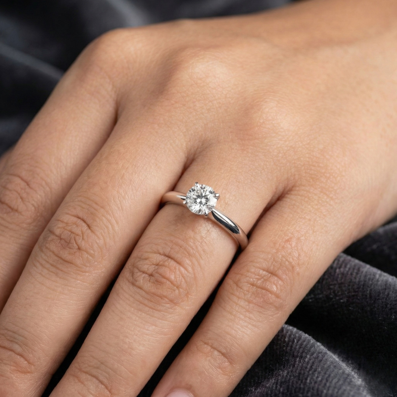 Diamond ring on a hand with a neutral background