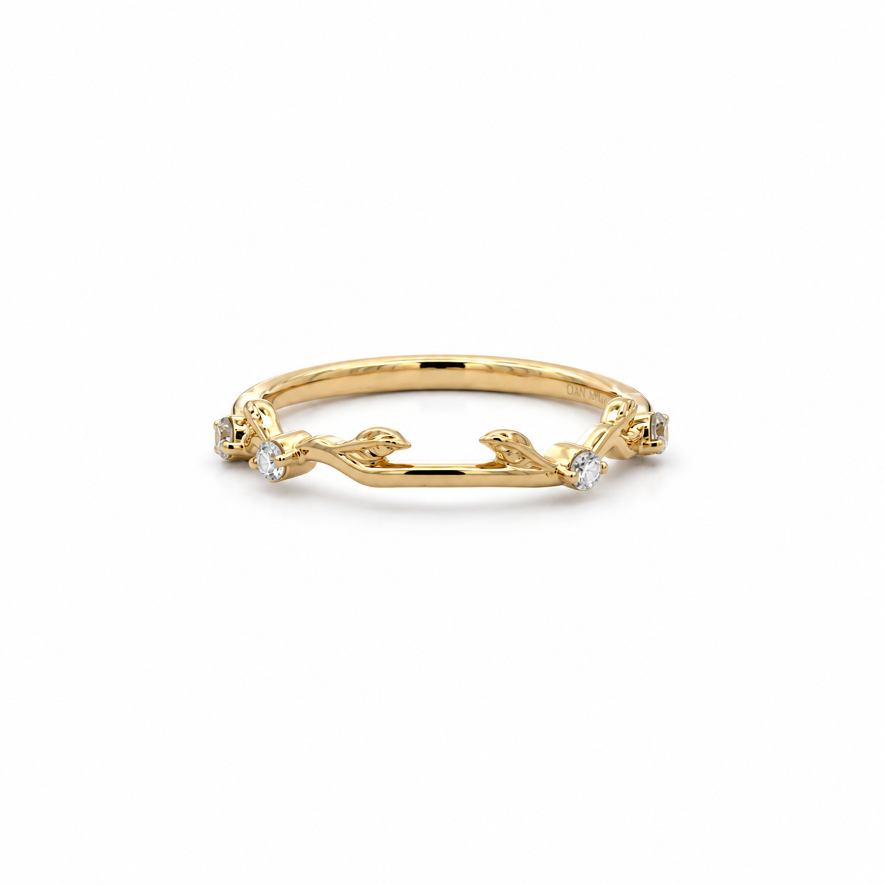 A delicate yellow gold ring featuring a branch-like design with small clear gemstones set along the band, photographed on a clean white background.