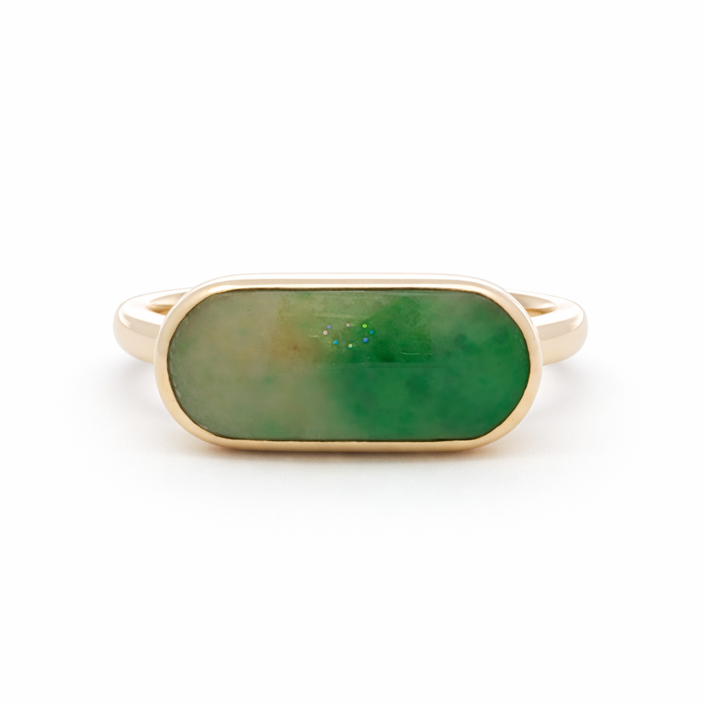 Gold ring with a green stone on a white background