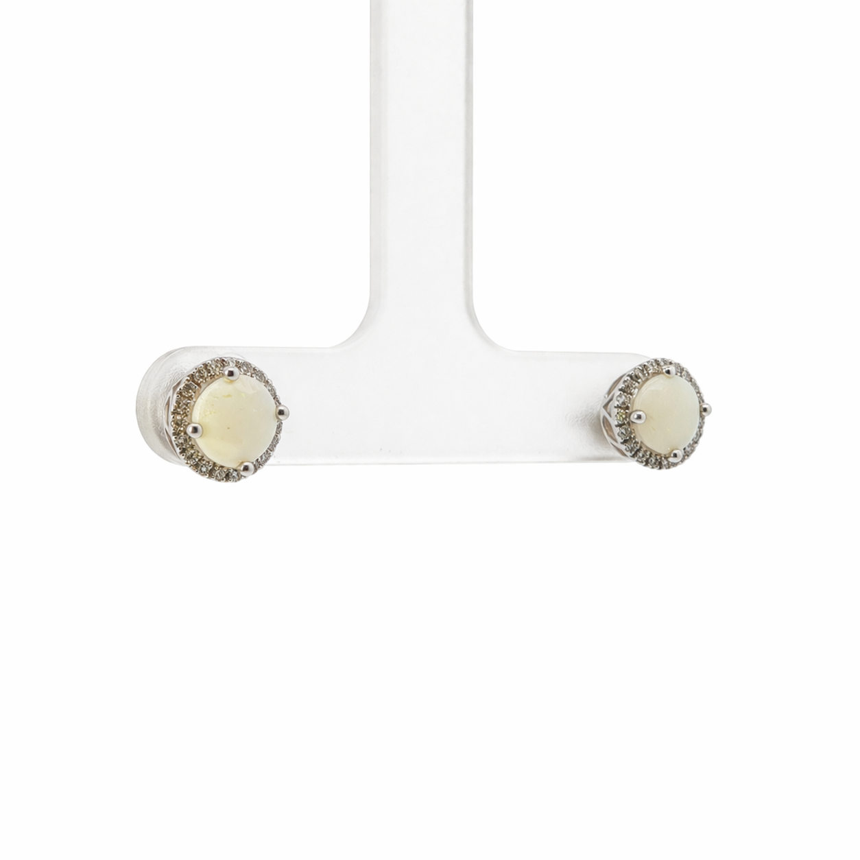 Pair of earrings with a white stone and silver border on a white background