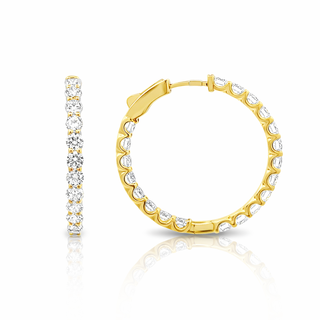 Gold hoop earrings with clear gemstones on a white background