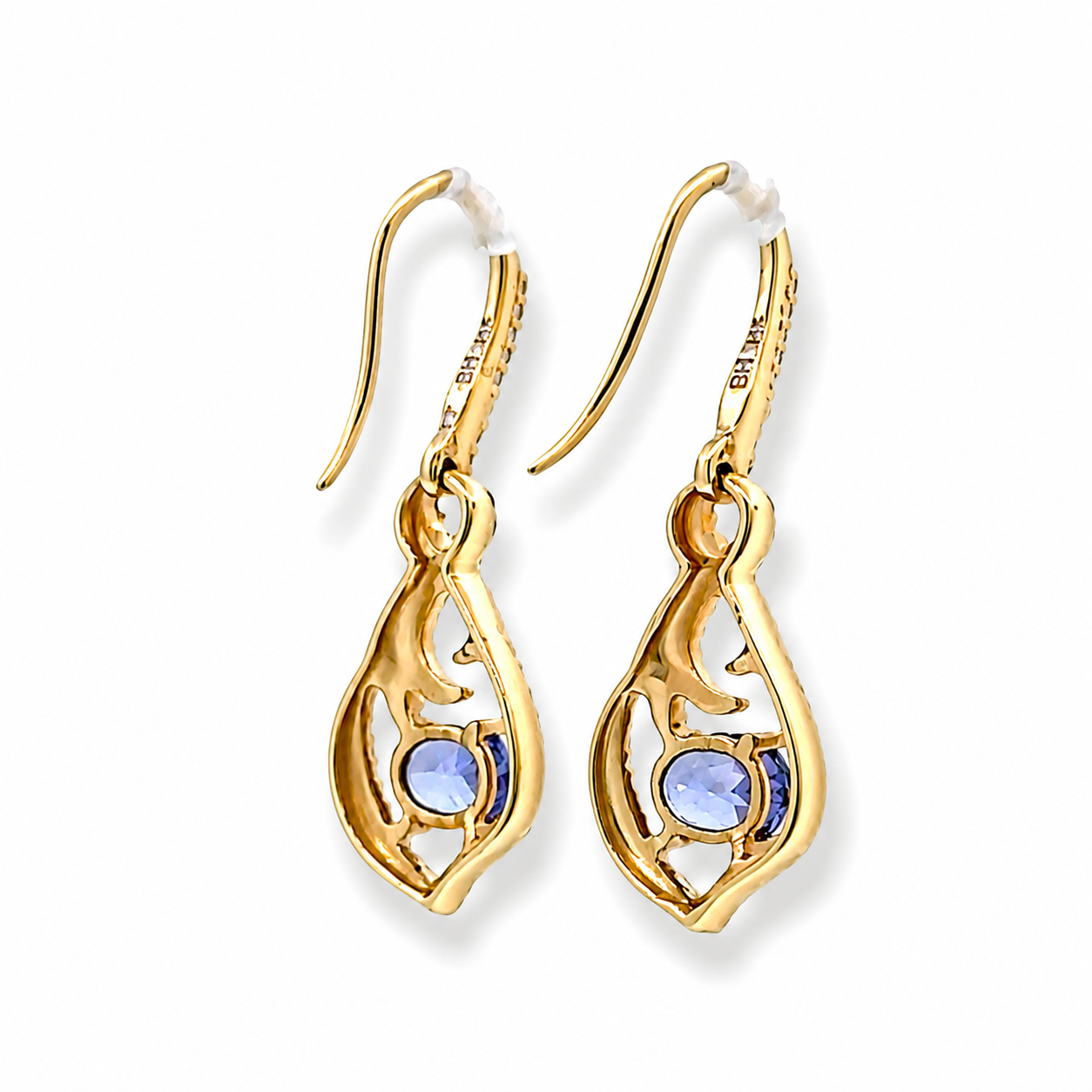 A pair of gold drop earrings with openwork filigree detailing and round blue gemstones, shown on a plain white background.