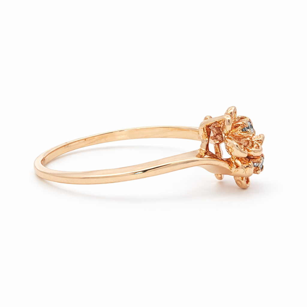 Rose gold ring with a decorative headpiece on a white background