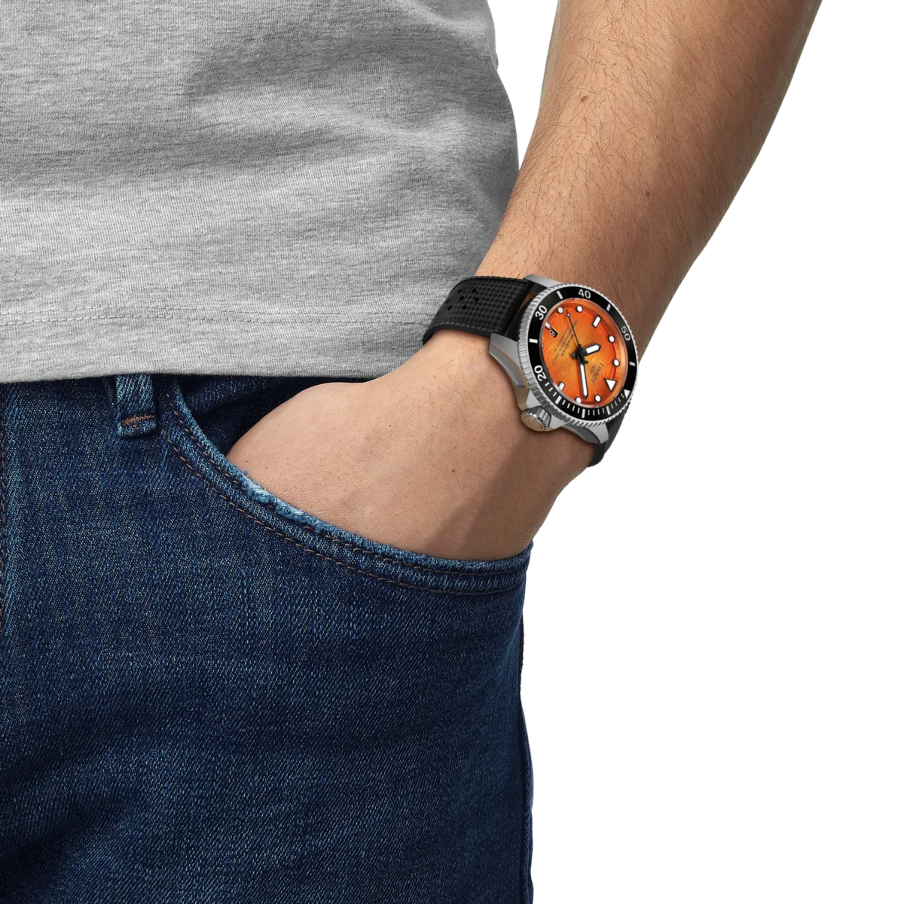 Person wearing a watch with an orange face and black strap, with a gray shirt and blue jeans.