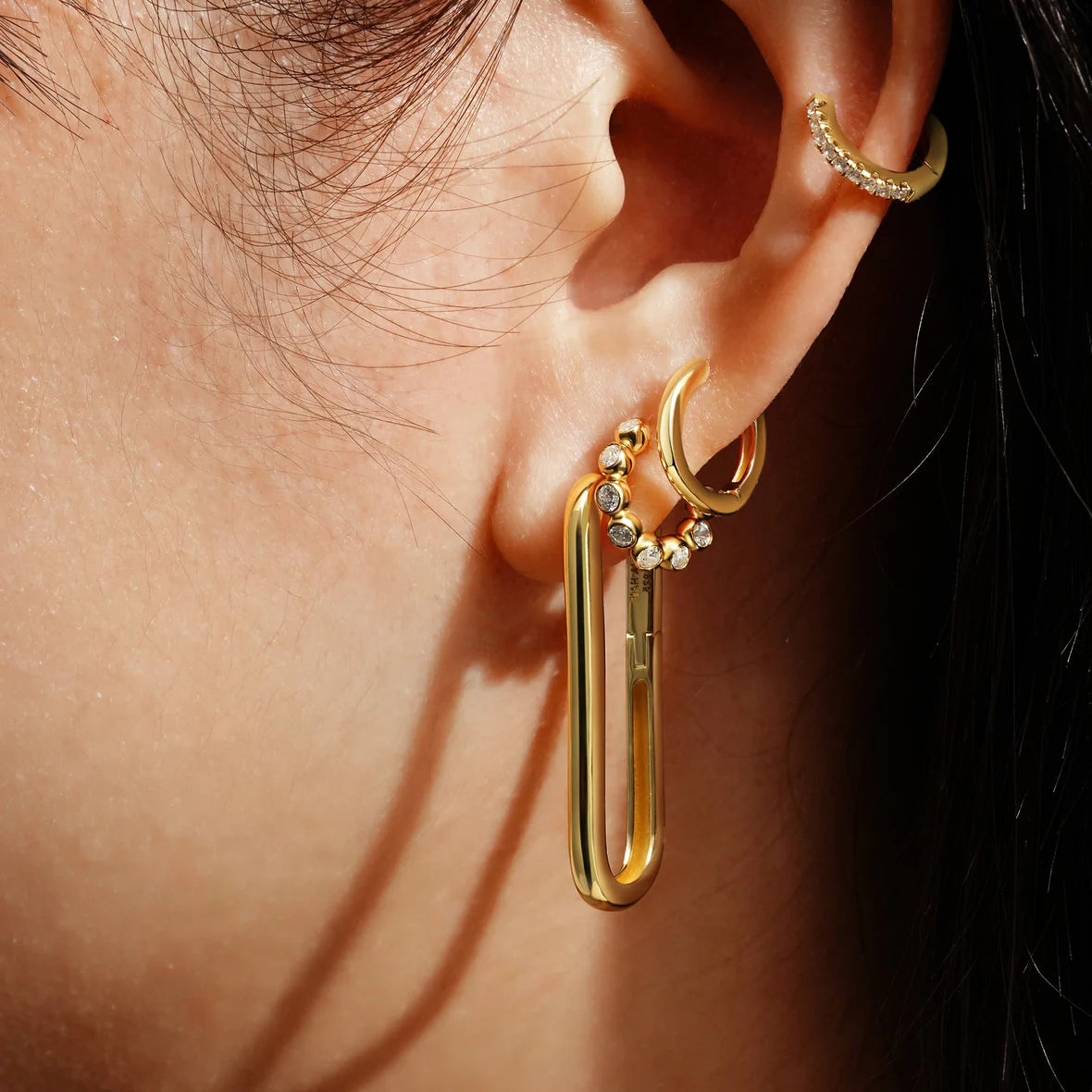 Huggie hoop earring stack modeled on human ear