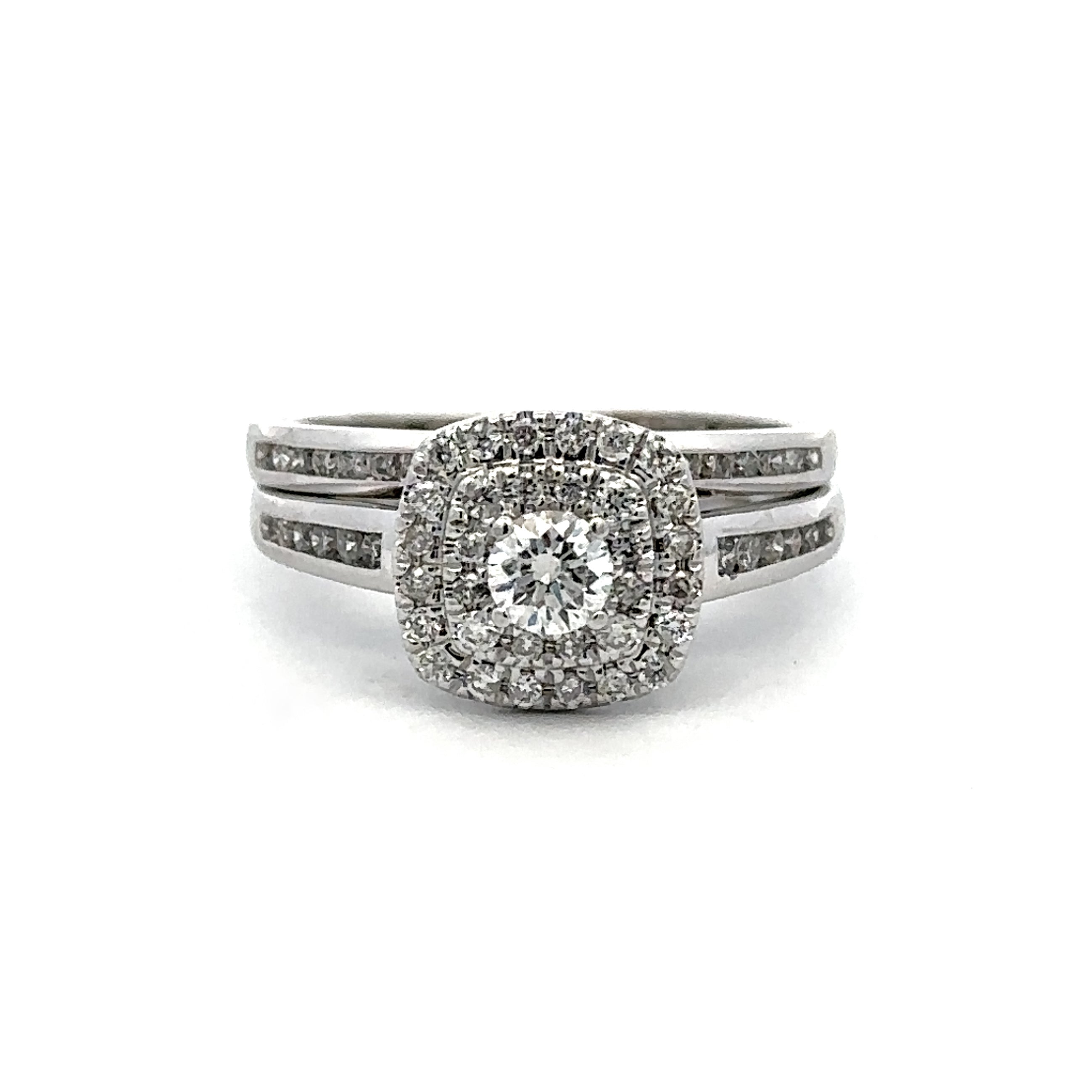 A silver-toned double band ring set featuring a central round diamond surrounded by a halo of smaller diamonds, with additional channel diamonds along the band, shown on a plain white background.