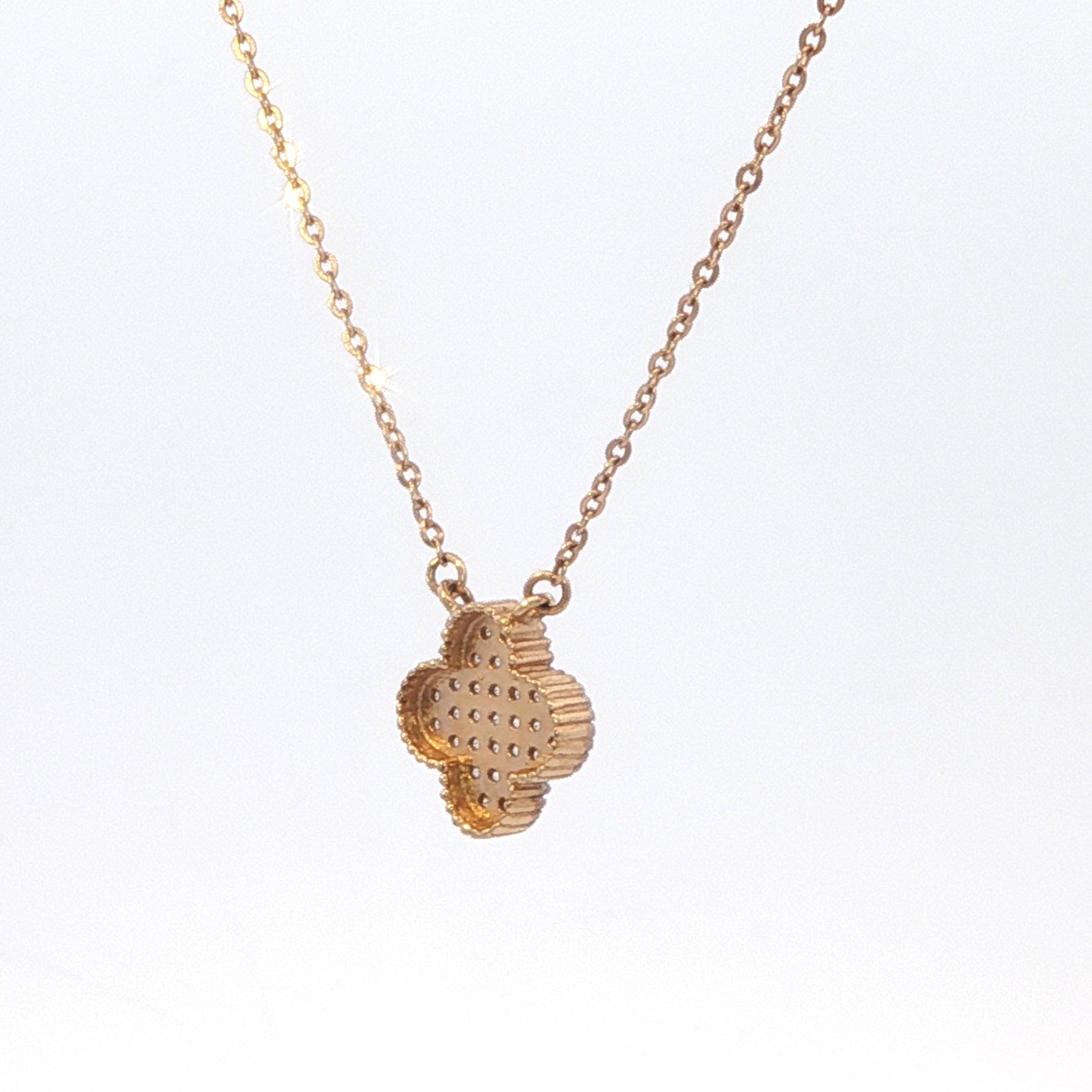 Gold necklace with a textured pendant on a white background