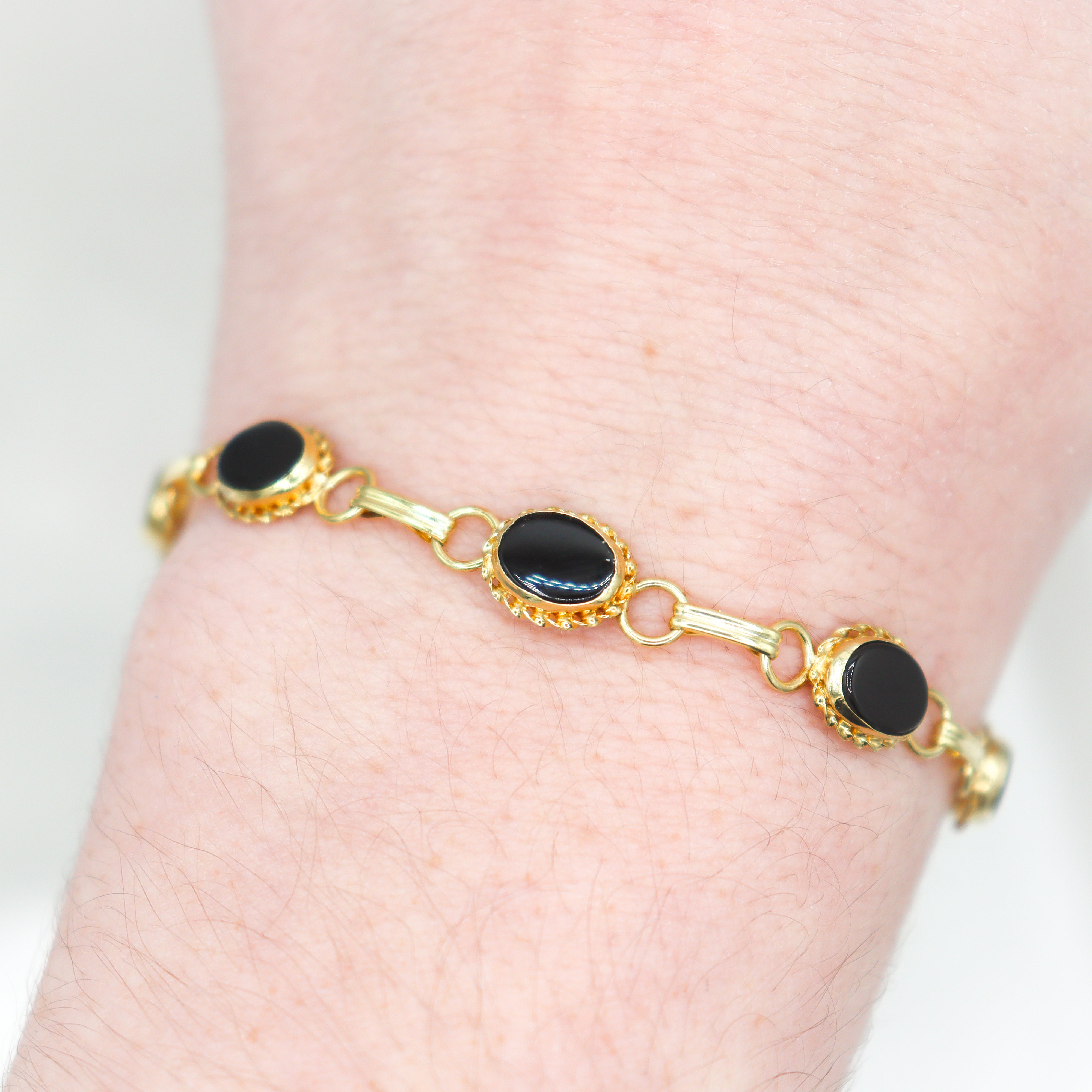 Top view estate 14k yellow gold black onyx bezel set with rope accents link bracelet