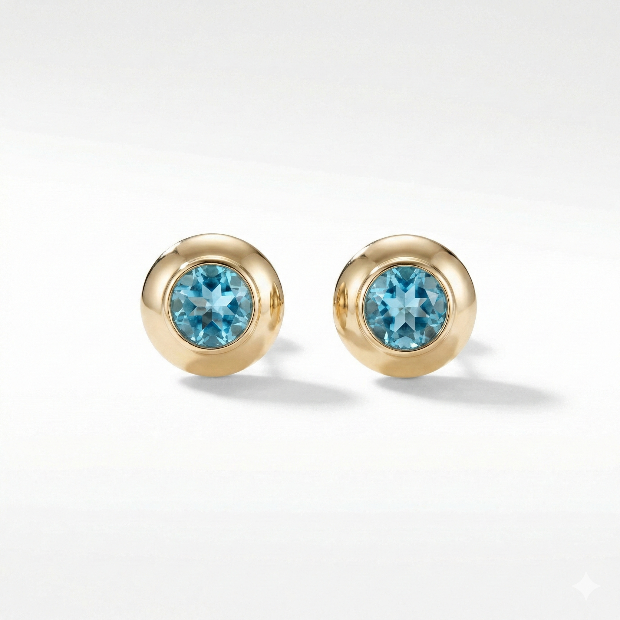 Gold earrings with blue gemstones on a white background