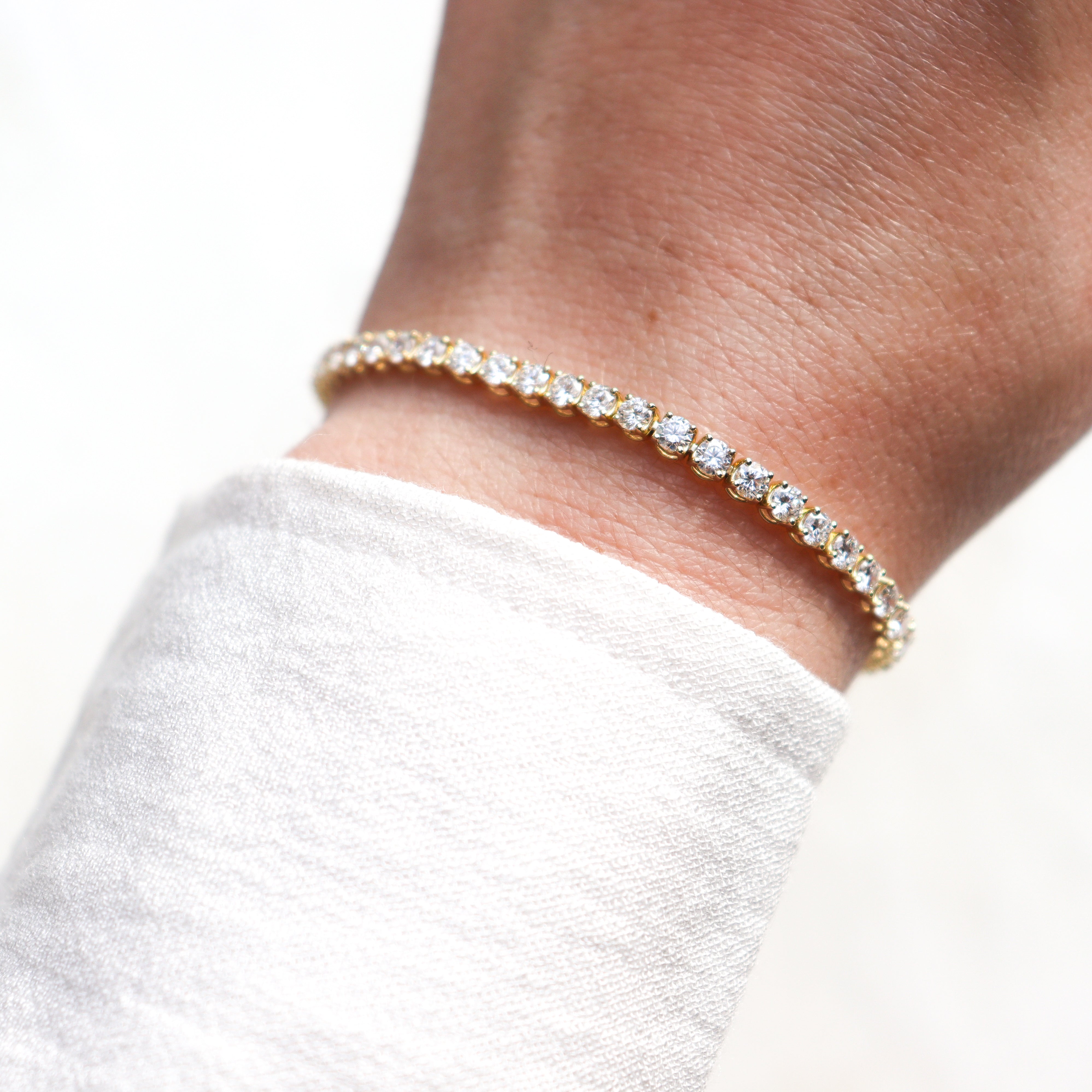 10K Yellow Gold 5CTW. Lab-Grown Diamond Tennis Bracelet on a model's wrist.