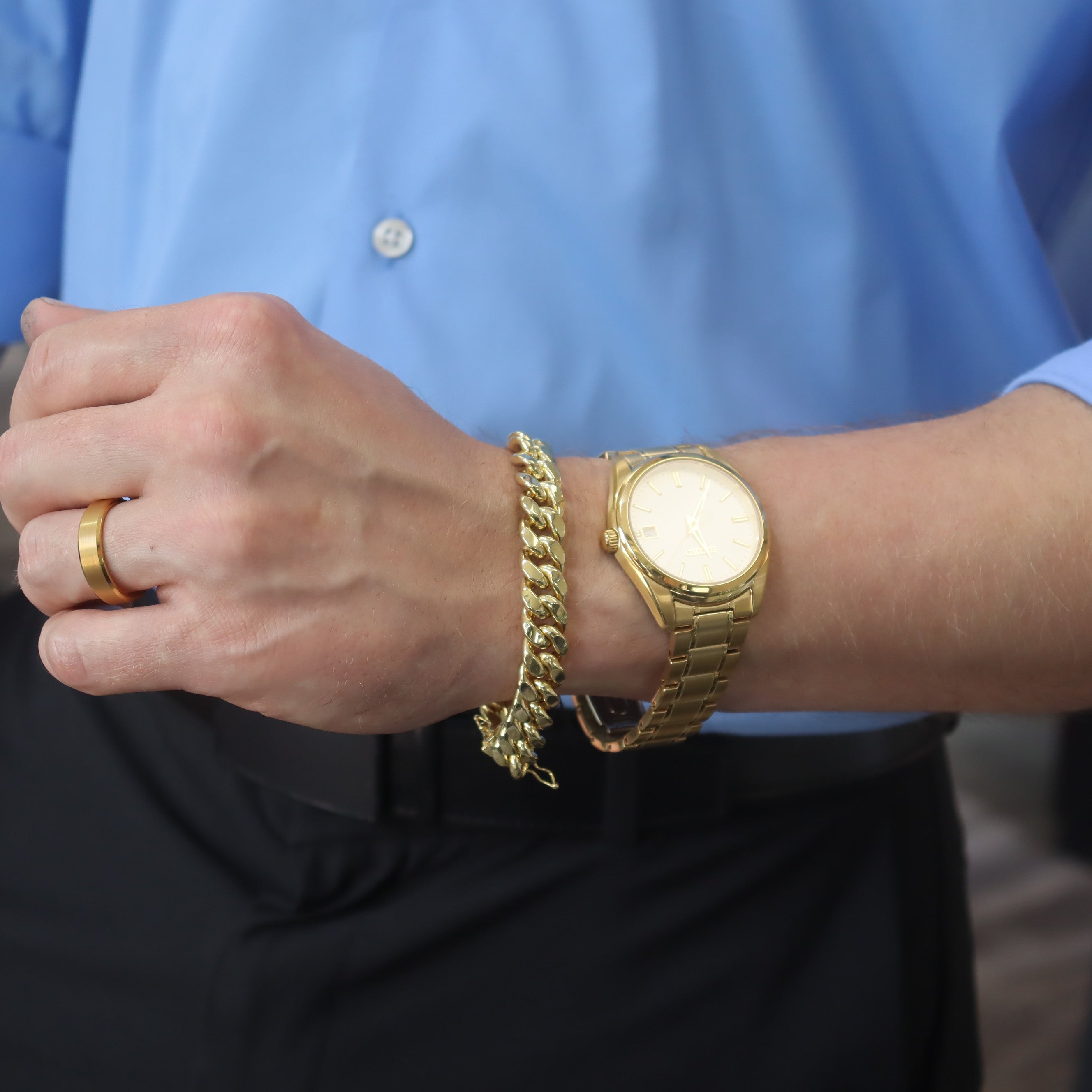 10K Yellow Gold 11.3mm Semi-Solid Miami Cuban Bracelet on a model's wrist, also wearing a gold-tone watch and a gold ring.