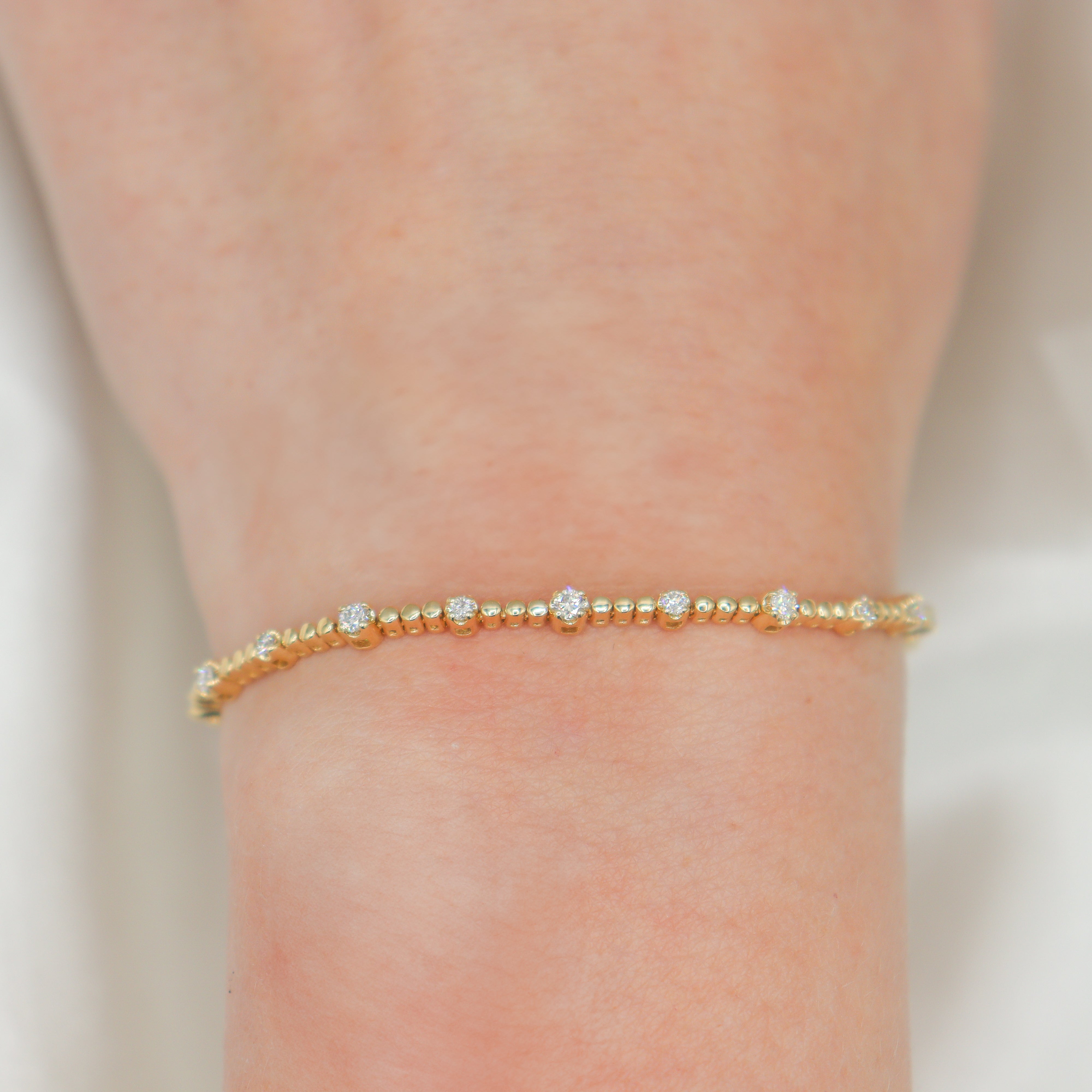 14K Yellow Gold 0.61CTW. Diamond Beaded Station Tennis Bracelet on a wrist