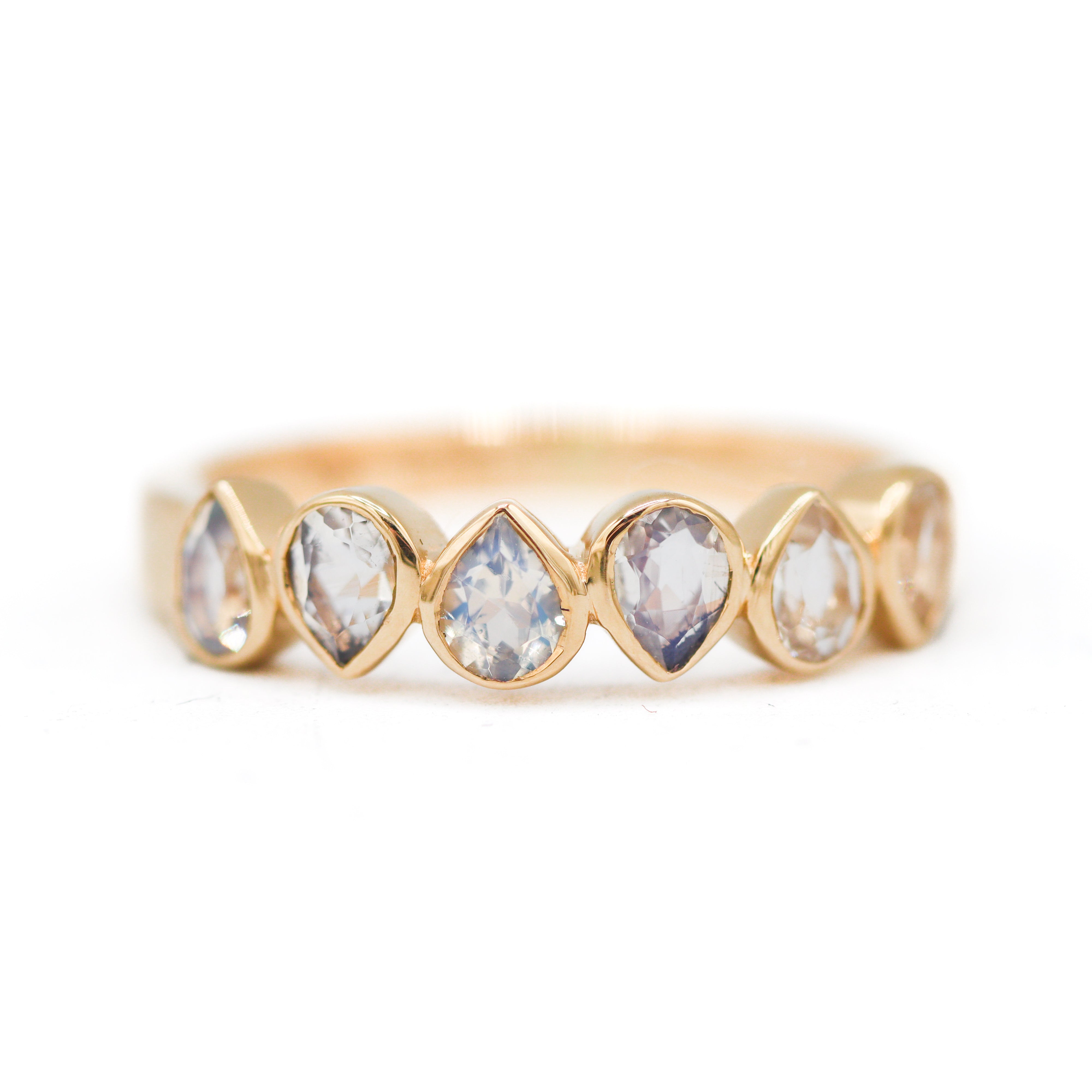 Gold ring with clear gemstones on a white background