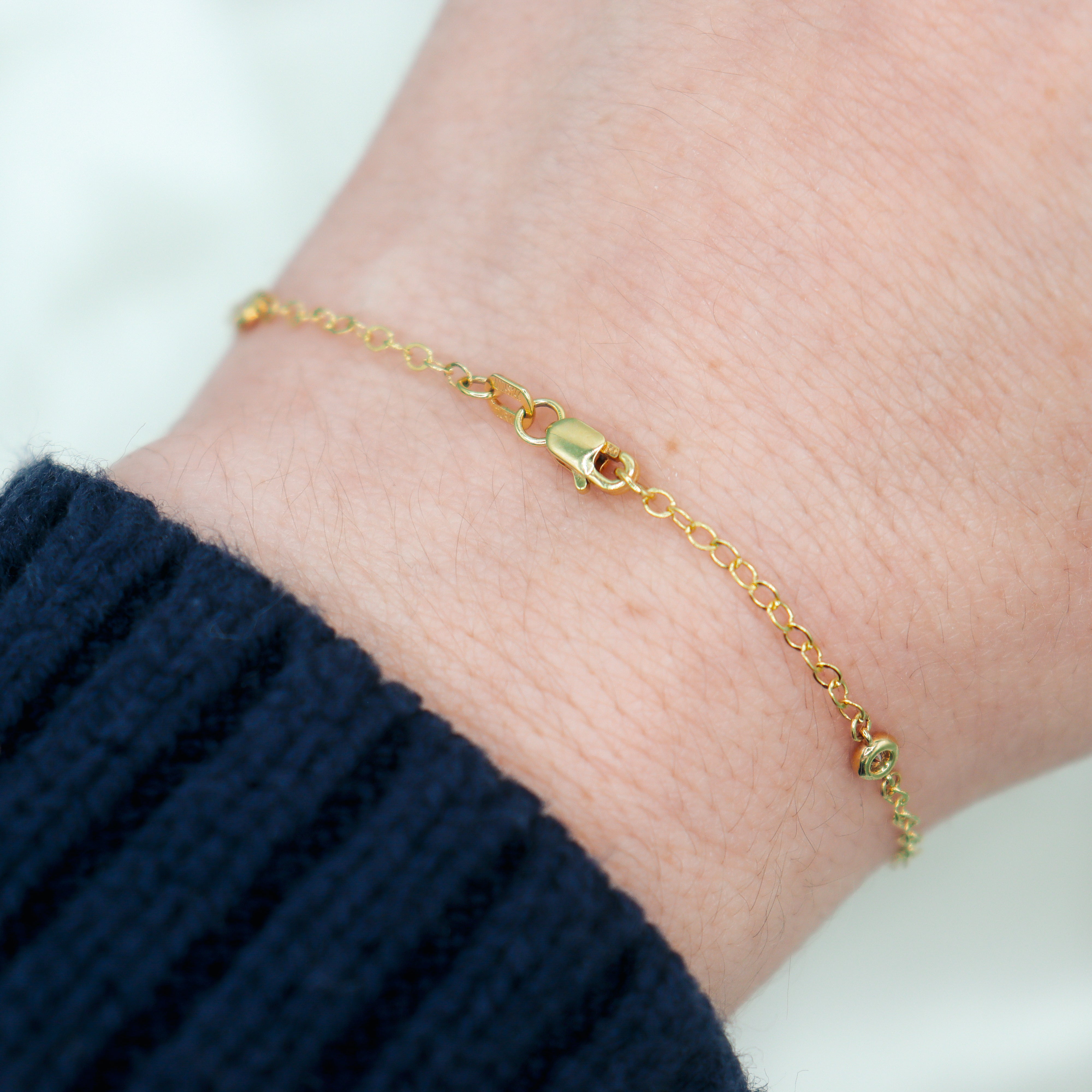 14K Yellow Gold 1/8CTW. Diamond Station Bracelet on a wrist showing the clasp