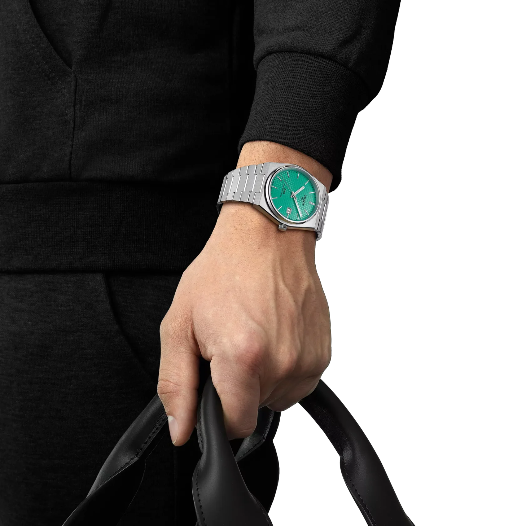 Hand wearing a silver watch with a green face on a white background