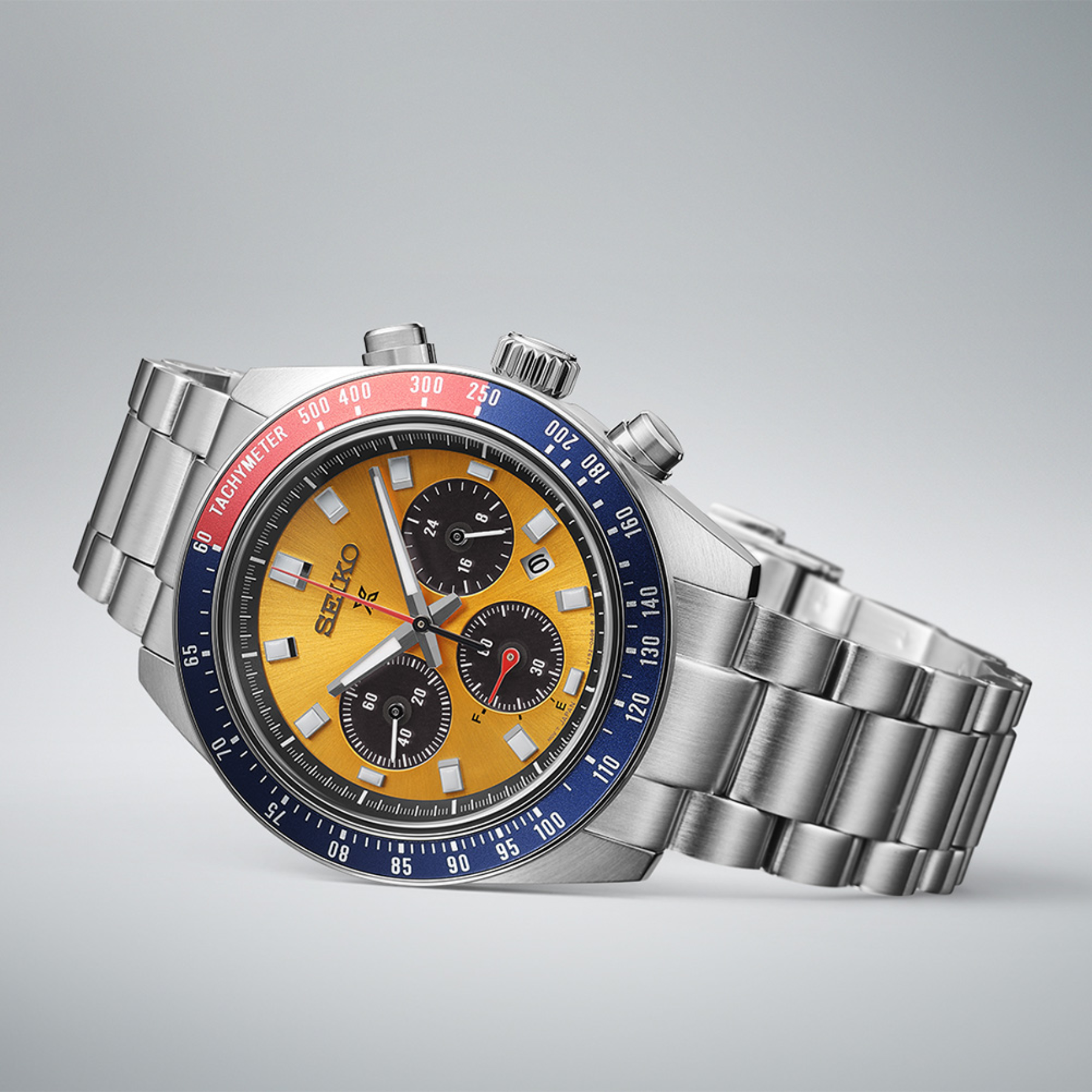 Seiko watch with a silver band and colorful face on a gray background