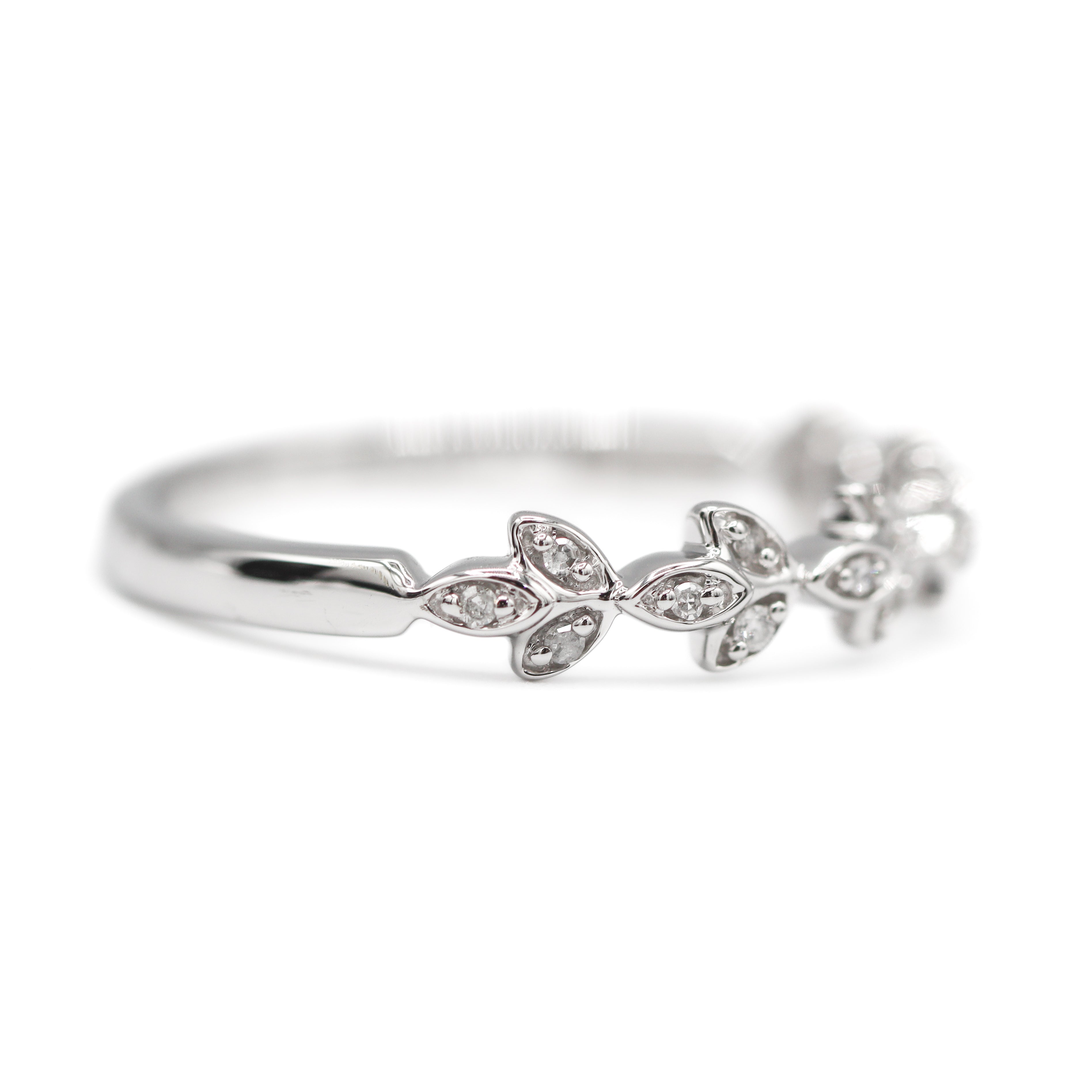 Facing right view of 10K White Gold 1/20CT. Diamond Leaf Marquise-Style Wedding Band laying flat on a white surface and background.