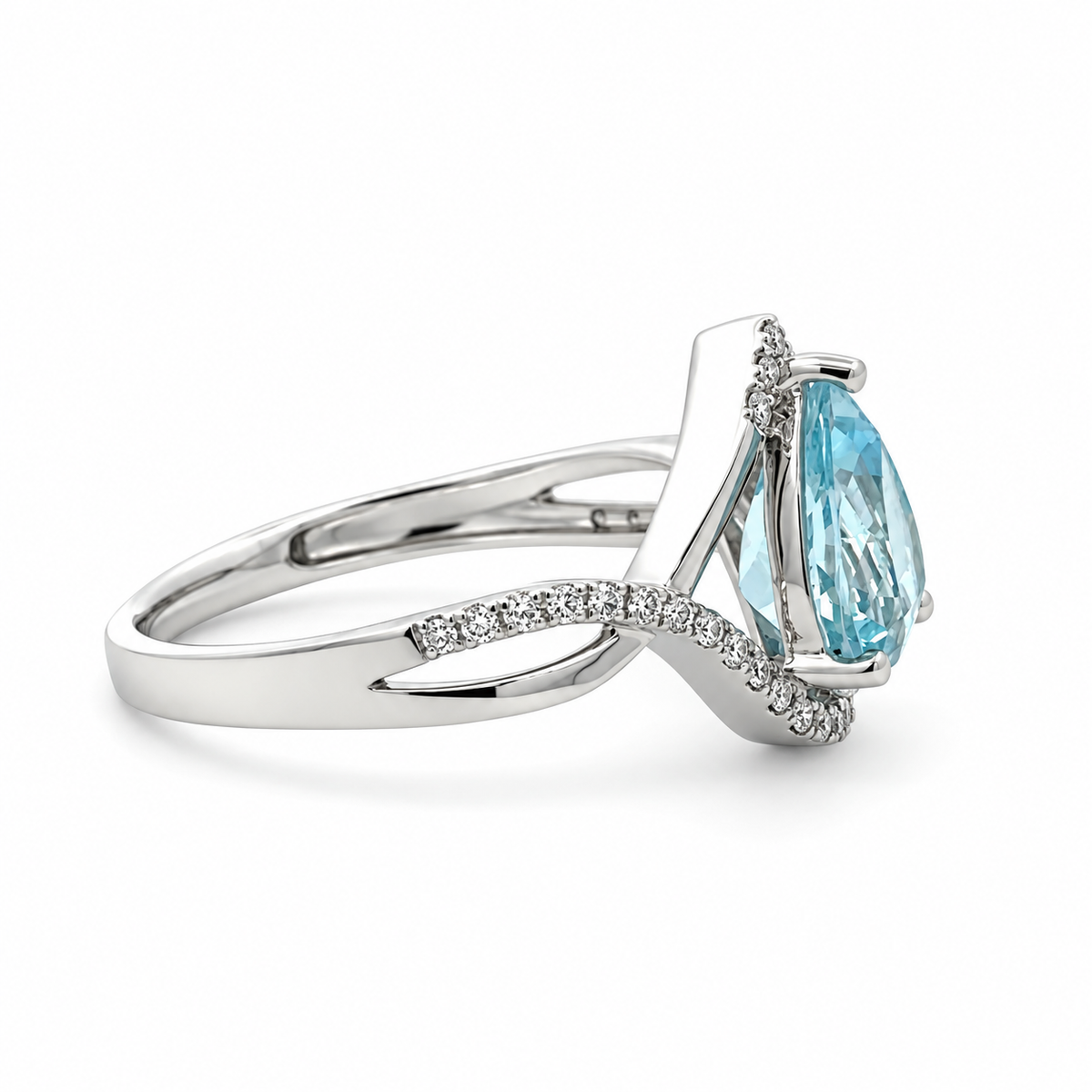Side view of a white gold aquamarine and diamond ring showing the raised pear-shaped center stone and open twisting shoulder.