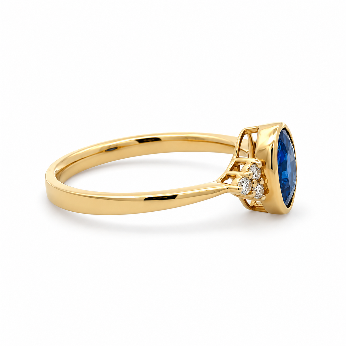 Side view of a yellow gold sapphire ring showing the raised oval bezel, open gallery and diamond shoulder accents.