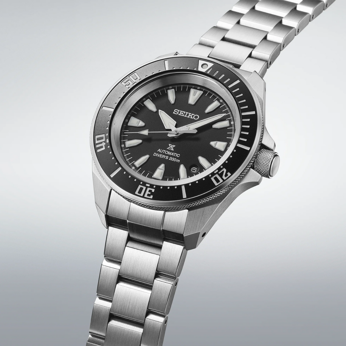 Seiko watch with silver metal strap on a light gray background