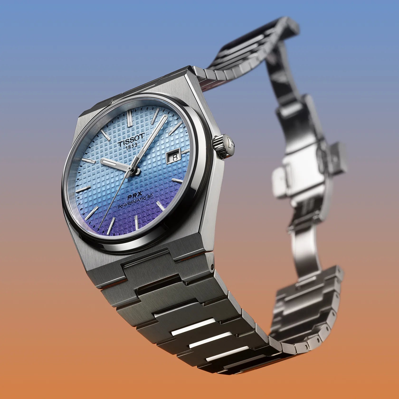 Silver Tissot watch with blue gradient face on a gradient background