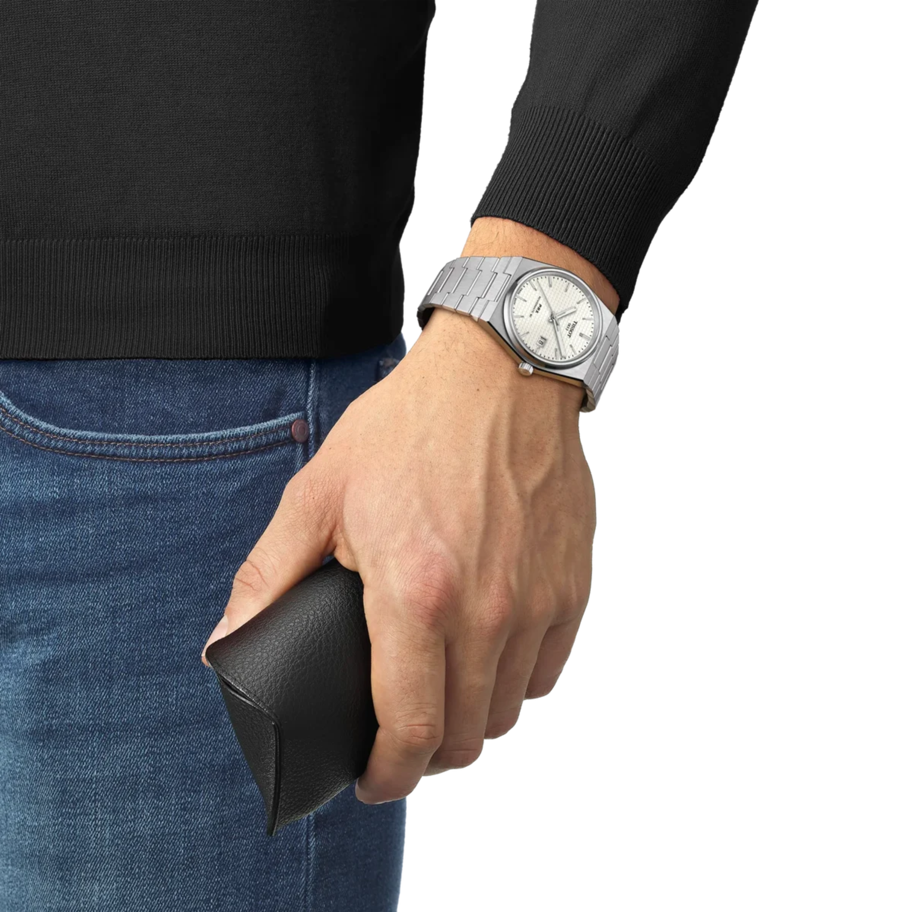 Hand wearing a silver watch holding a black wallet against a white background