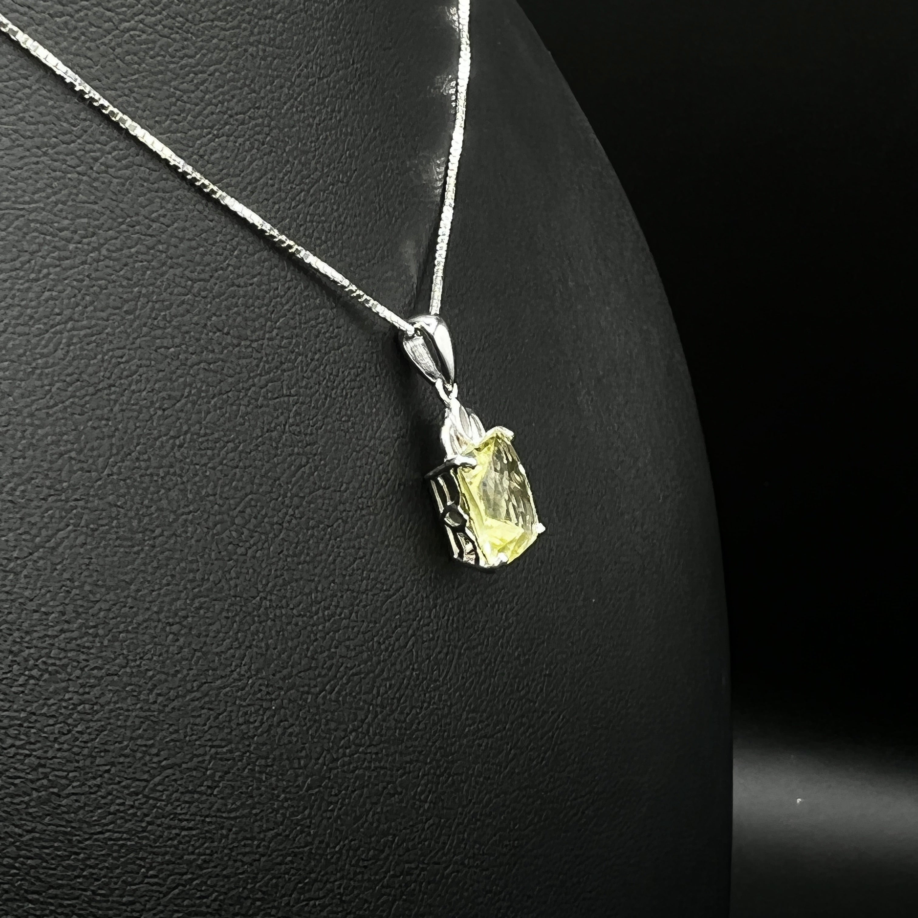The image shows a sterling silver elongated-cushion lemon quartz pendant necklace on a mannequin.