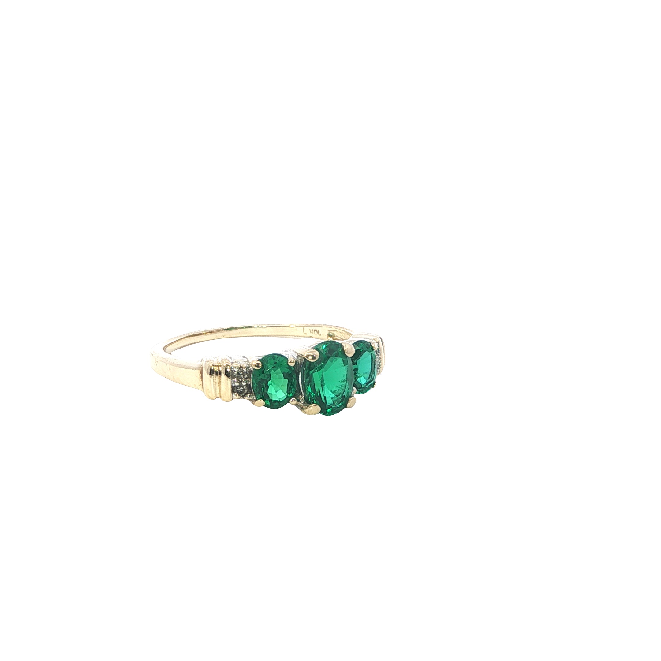 Gold ring with three green gemstones on a white background
