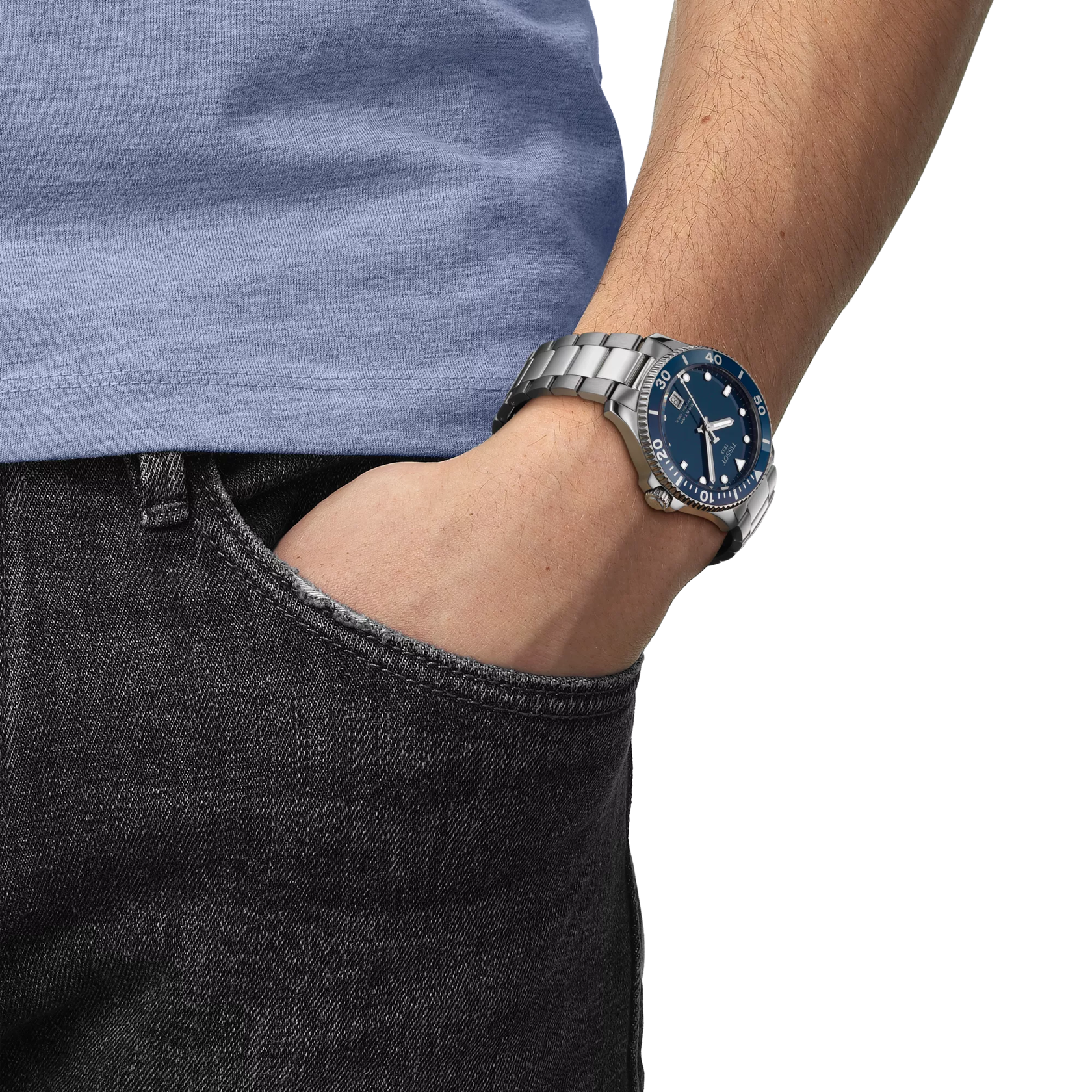 Person wearing a silver watch with a blue face on a plain background