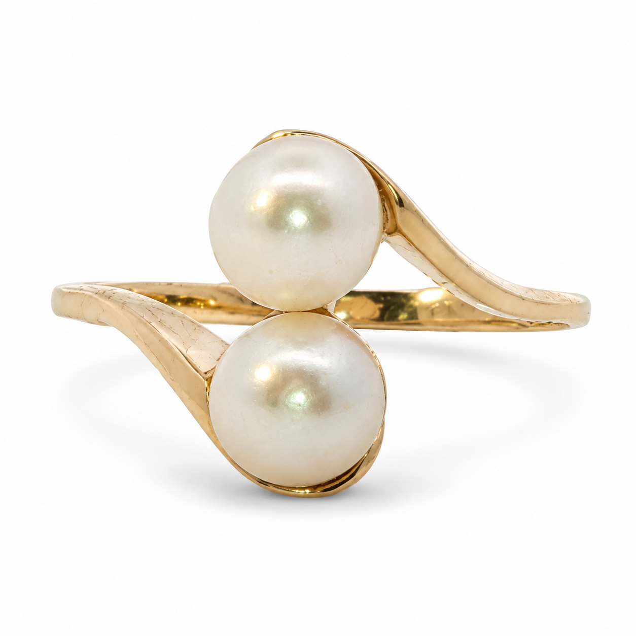 Front view of an estate 10K yellow gold toi et moi bypass ring with two round cream-colored pearls.