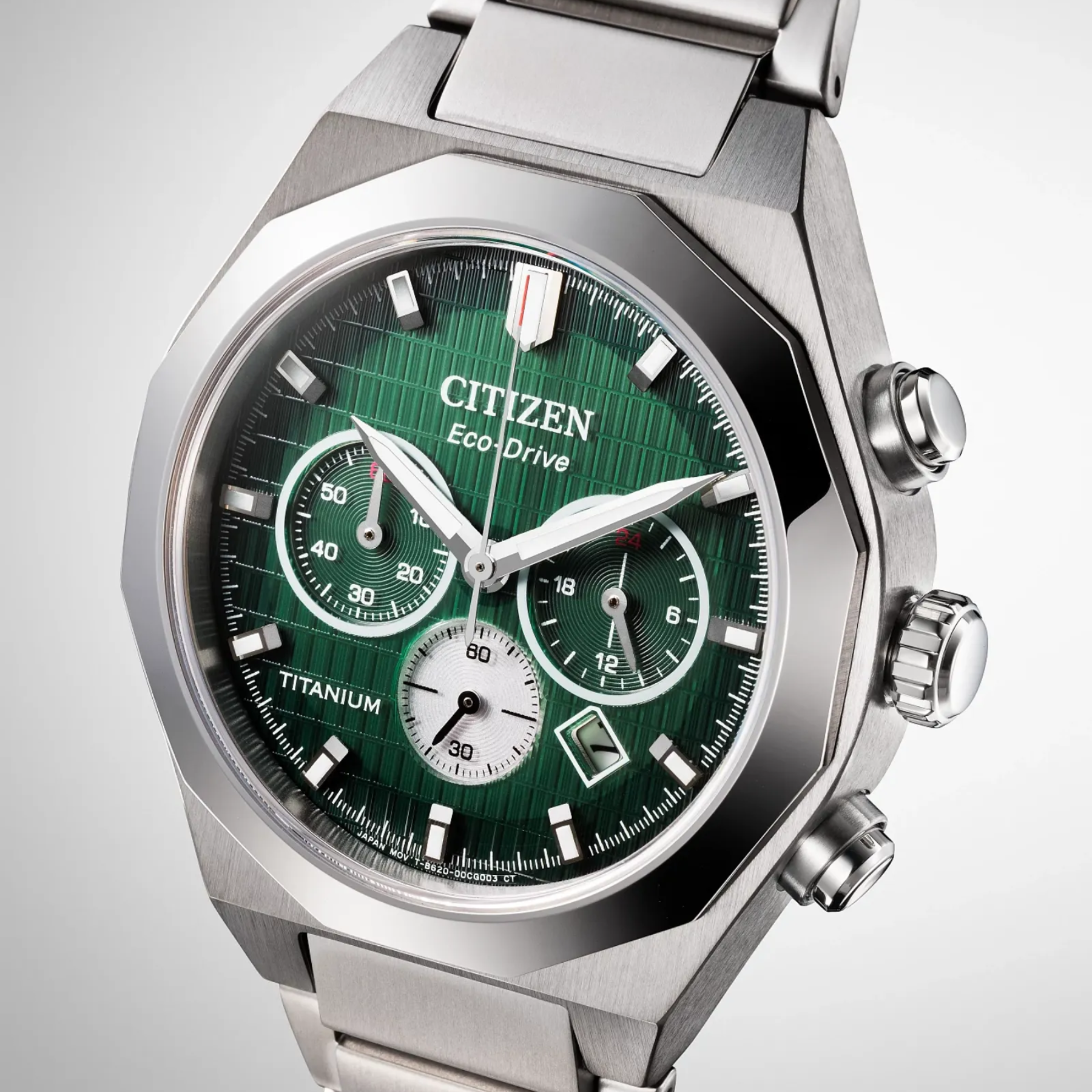 Citizen watch with green dial and silver metal strap on a light gray background