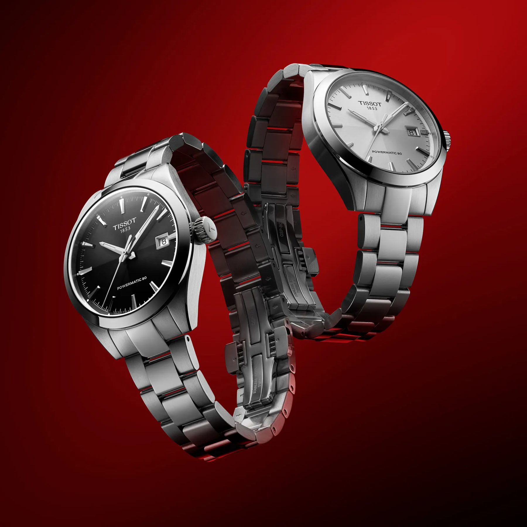 Two silver watches with black and silver faces on a red background
