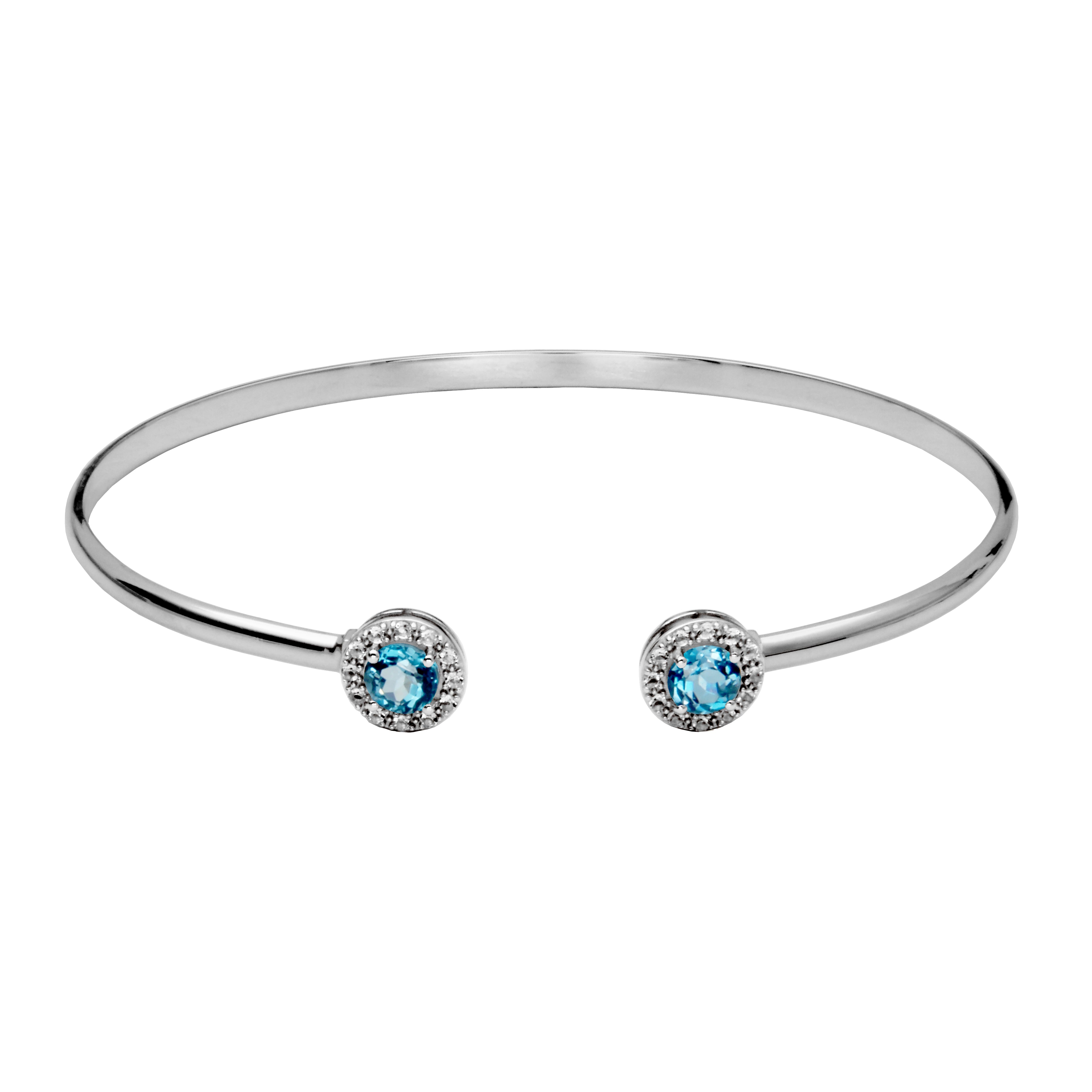 Silver cuff bangle bracelet. On each end of the buff is a round london blue topaz gemstone surrounded by a halo of white topaz.