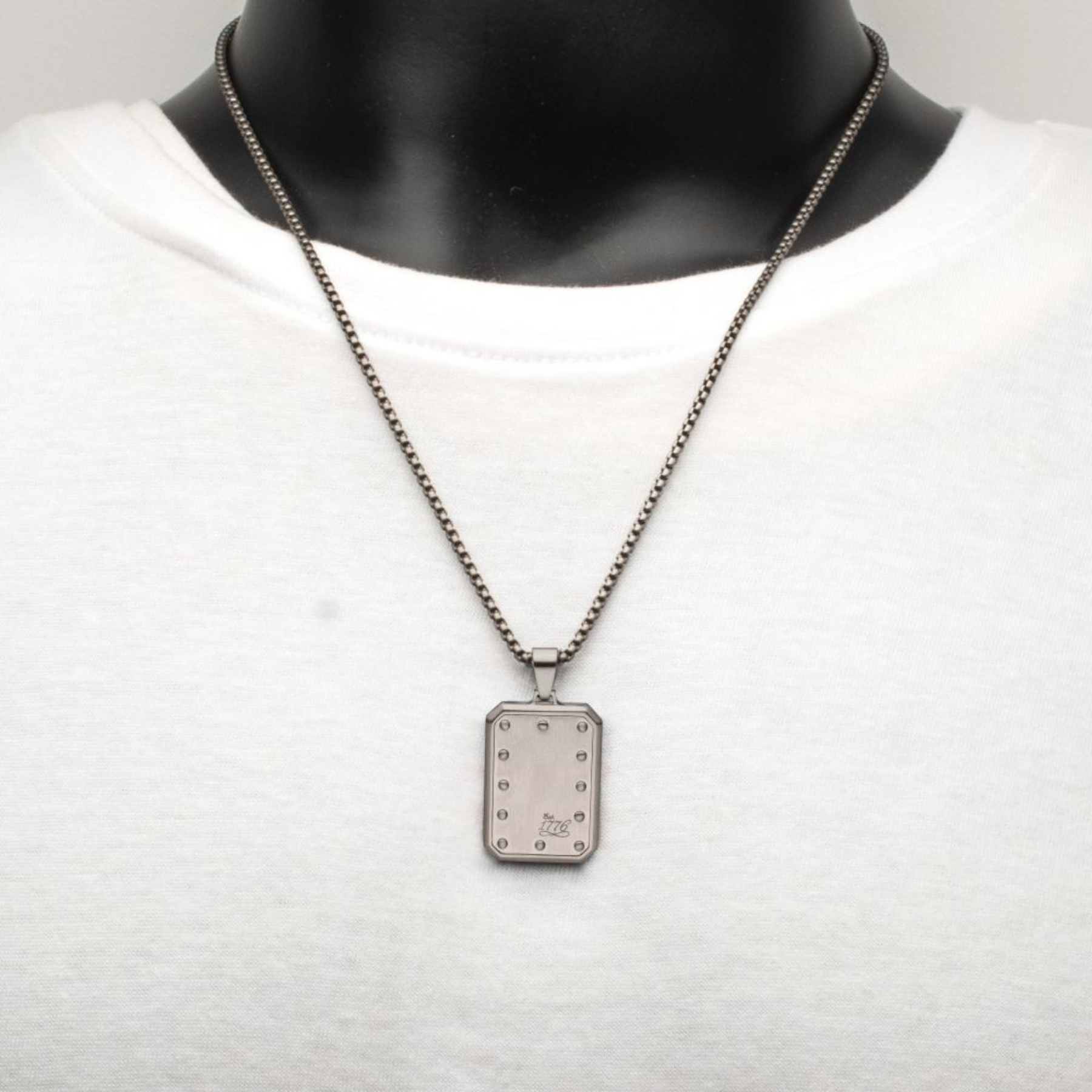 Necklace with a rectangular pendant on a white shirt
