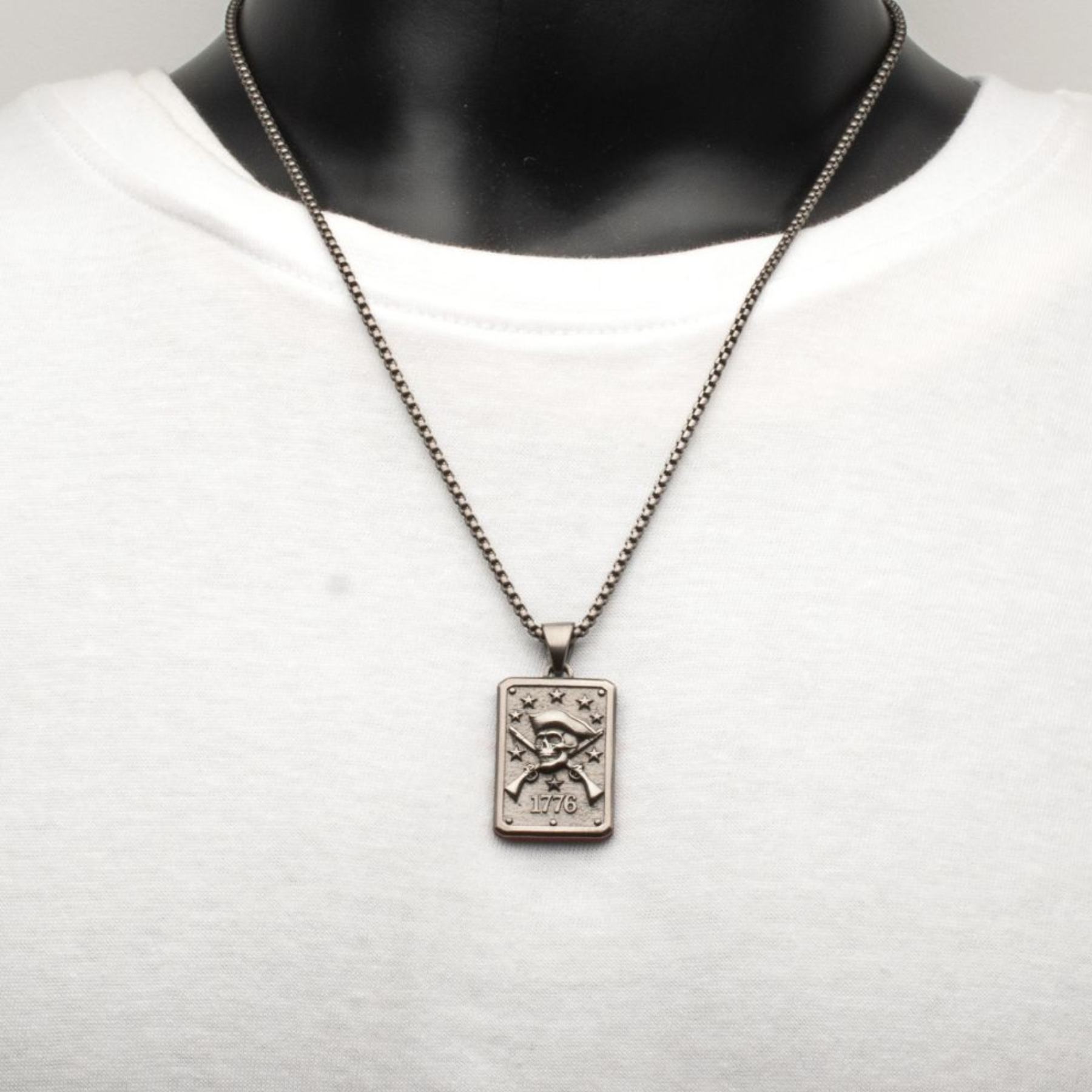 Silver necklace with a pendant on a mannequin against a white background