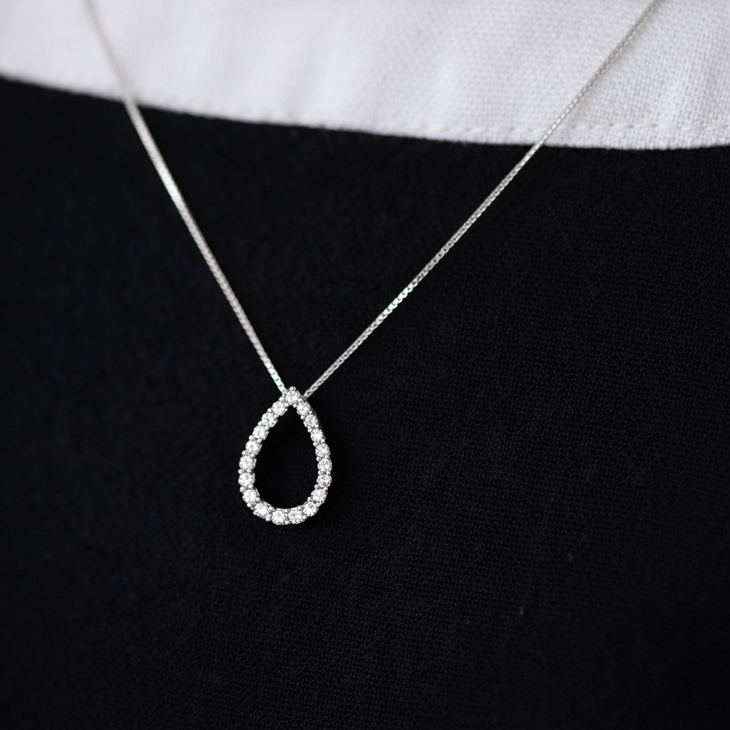 Teardrop-shaped diamond pendant on a black background