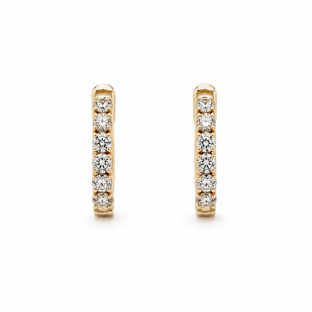 Gold hoop earrings with embedded diamonds on a white background