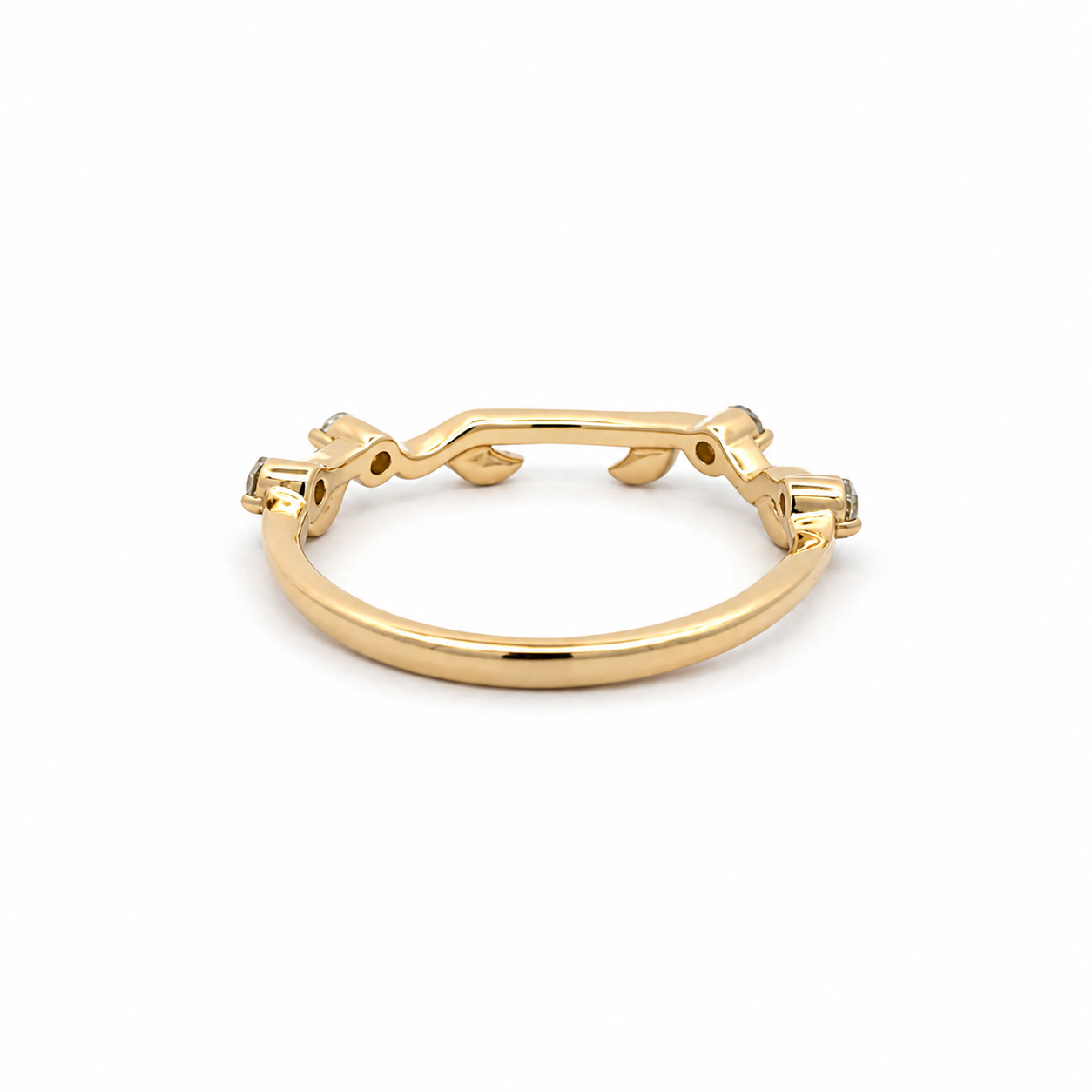 A polished yellow gold huggie ring with decorative leaf-like details on the sides, shown on a clean white background.