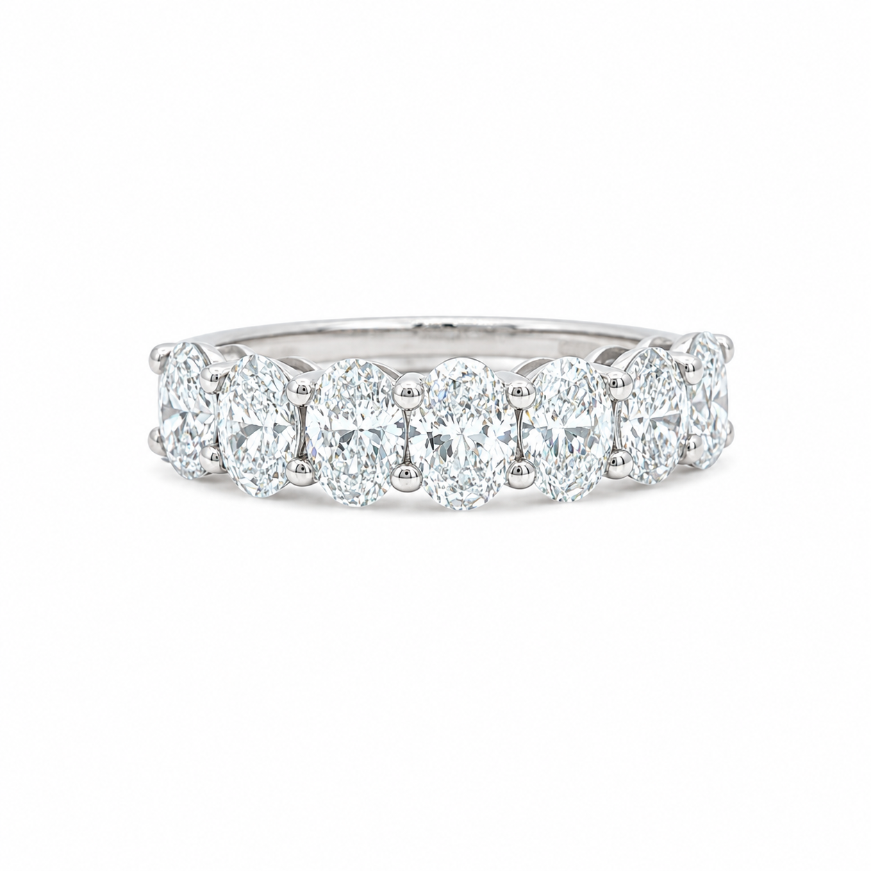 A diamond eternity ring featuring a row of oval-cut diamonds set in a polished silver-colored band, shown against a plain white background.
